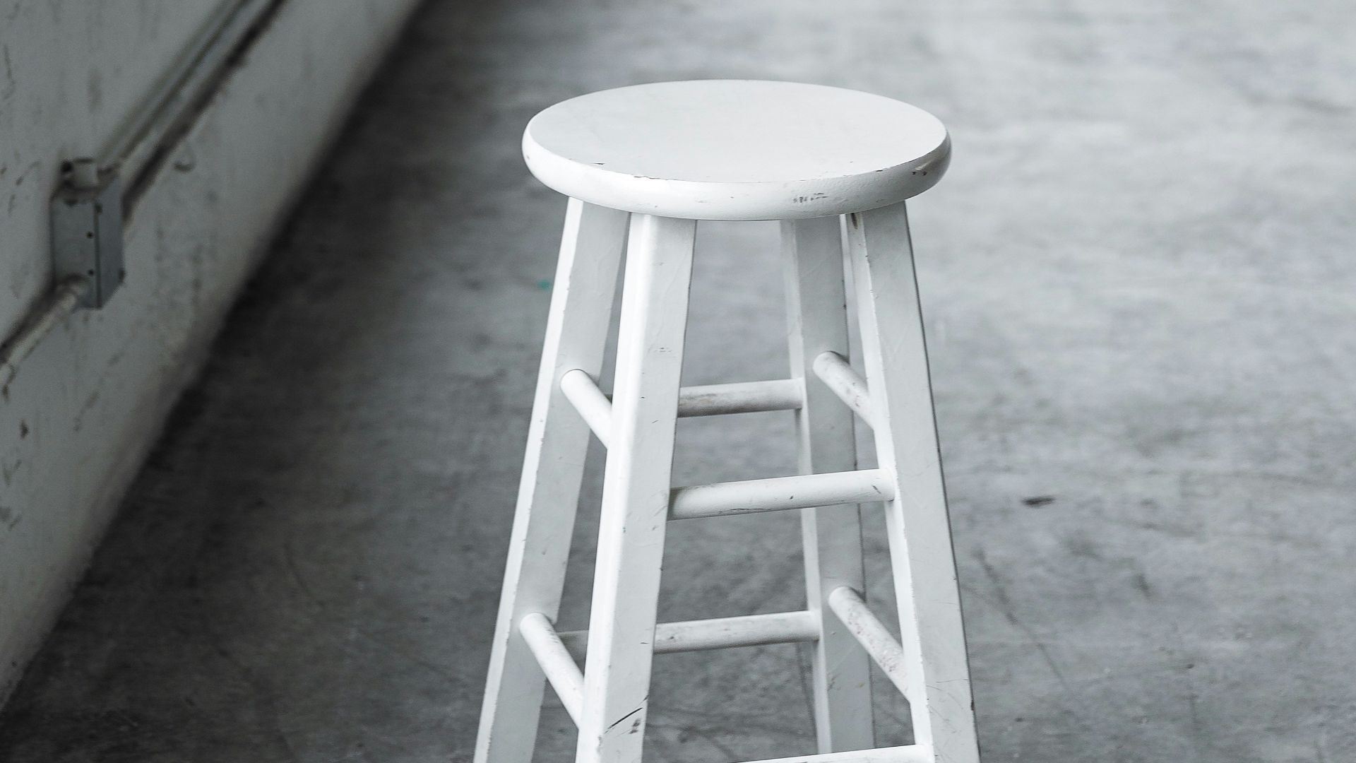 round white wooden stool near closed window