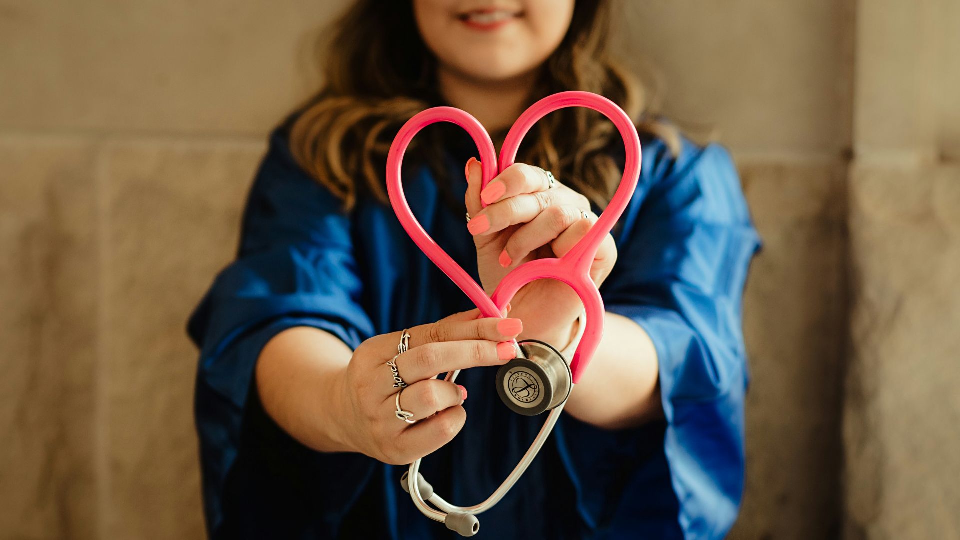 girl in blue jacket holding red and silver ring