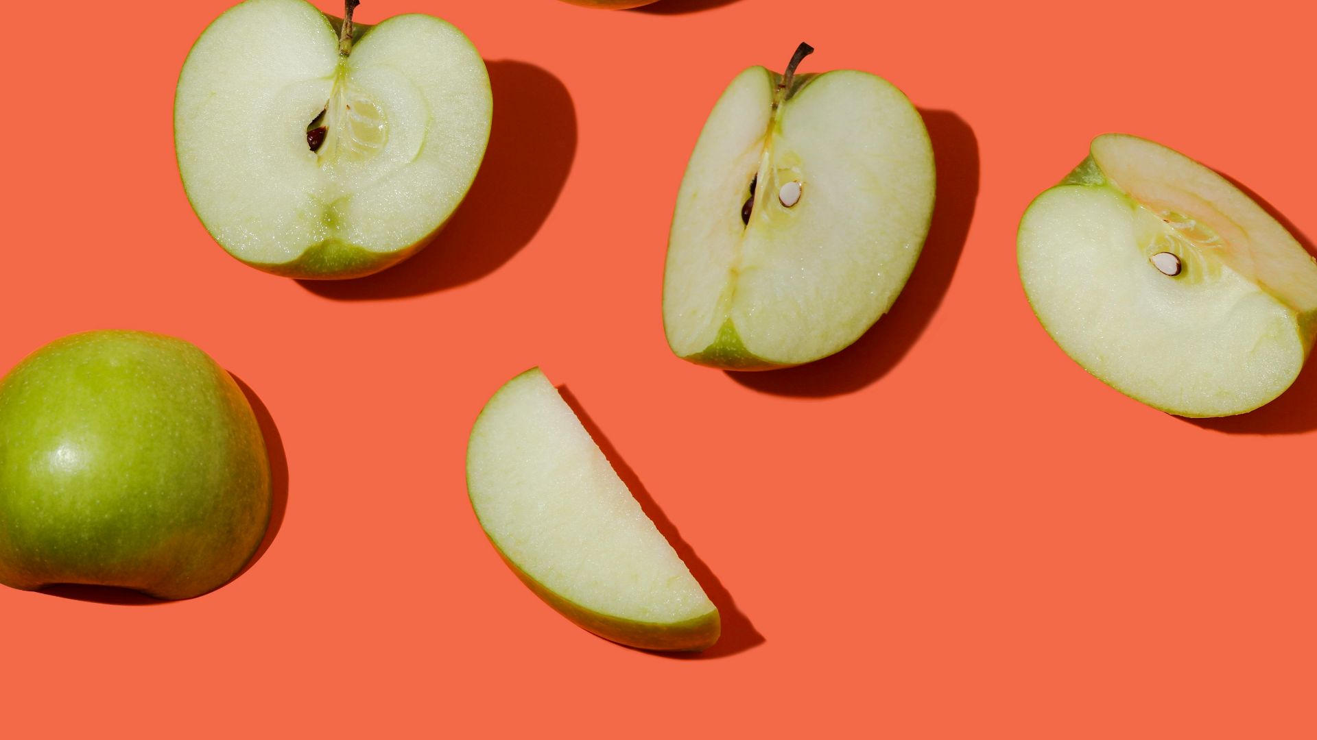 green apple fruit on pink surface