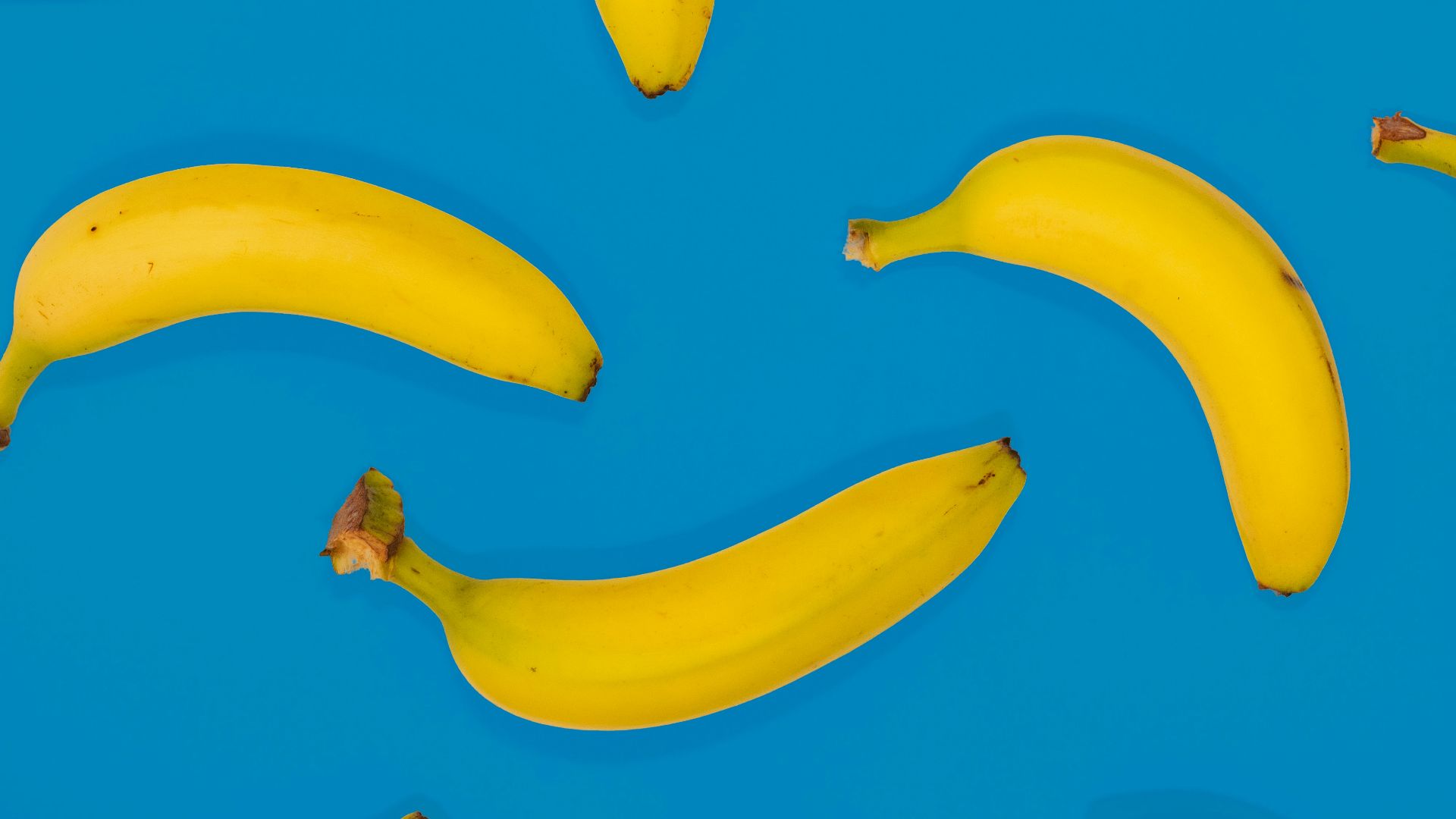 yellow banana fruits on blue surface