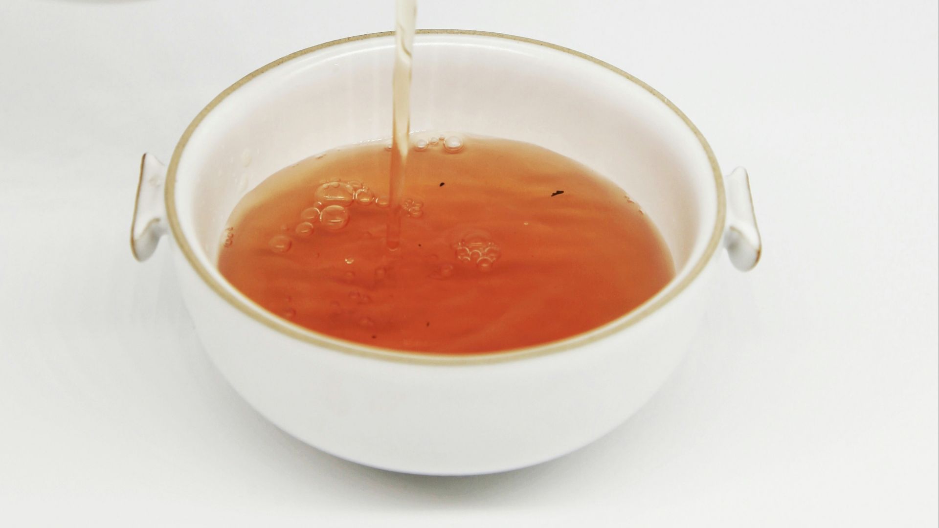 tea pours into white teacup