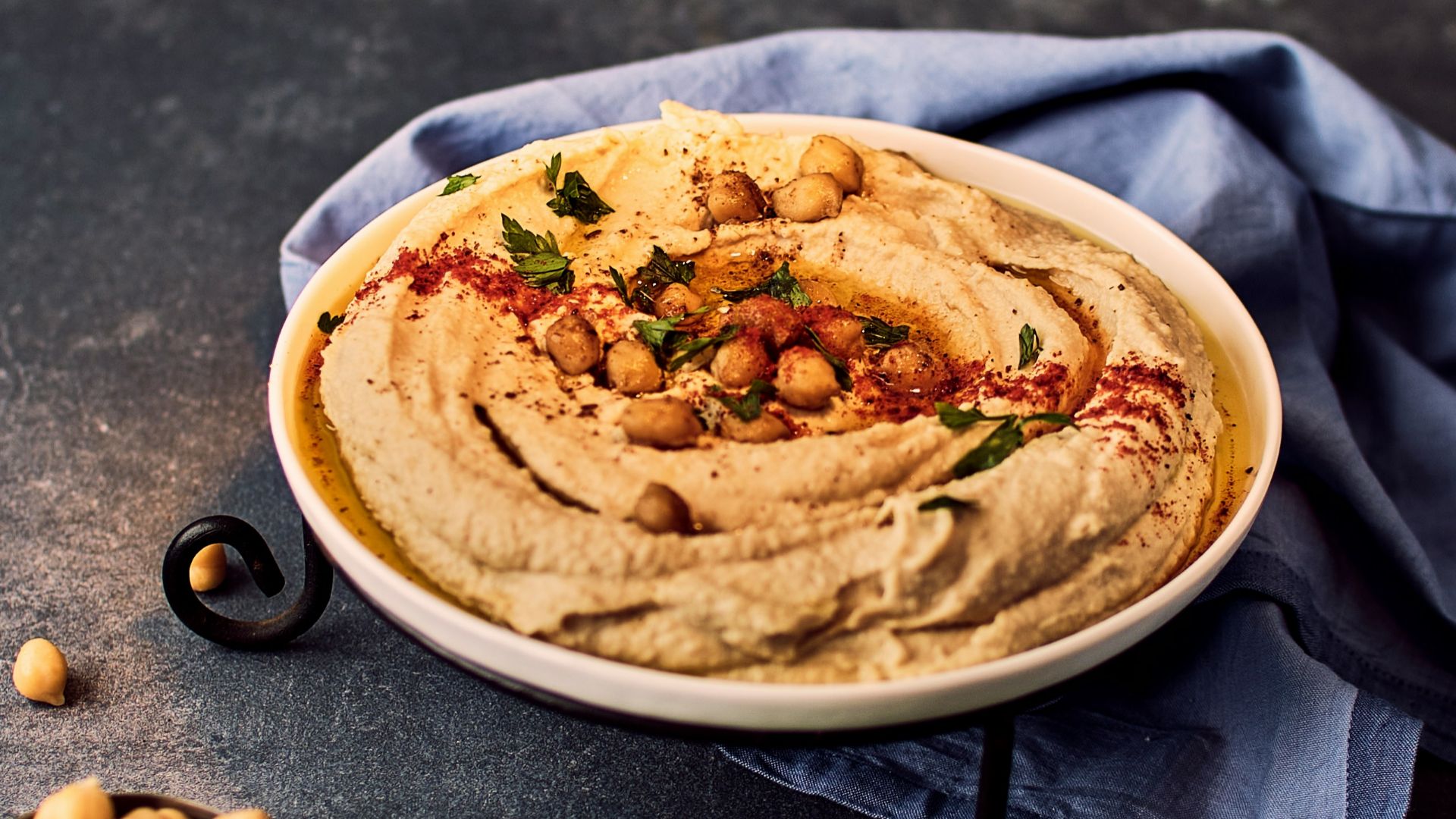 a bowl of hummus with chickpeas on the side