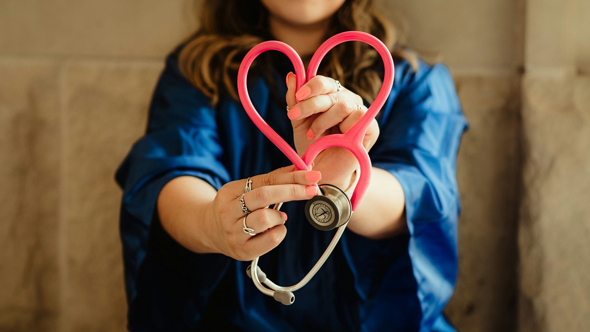 girl in blue jacket holding red and silver ring