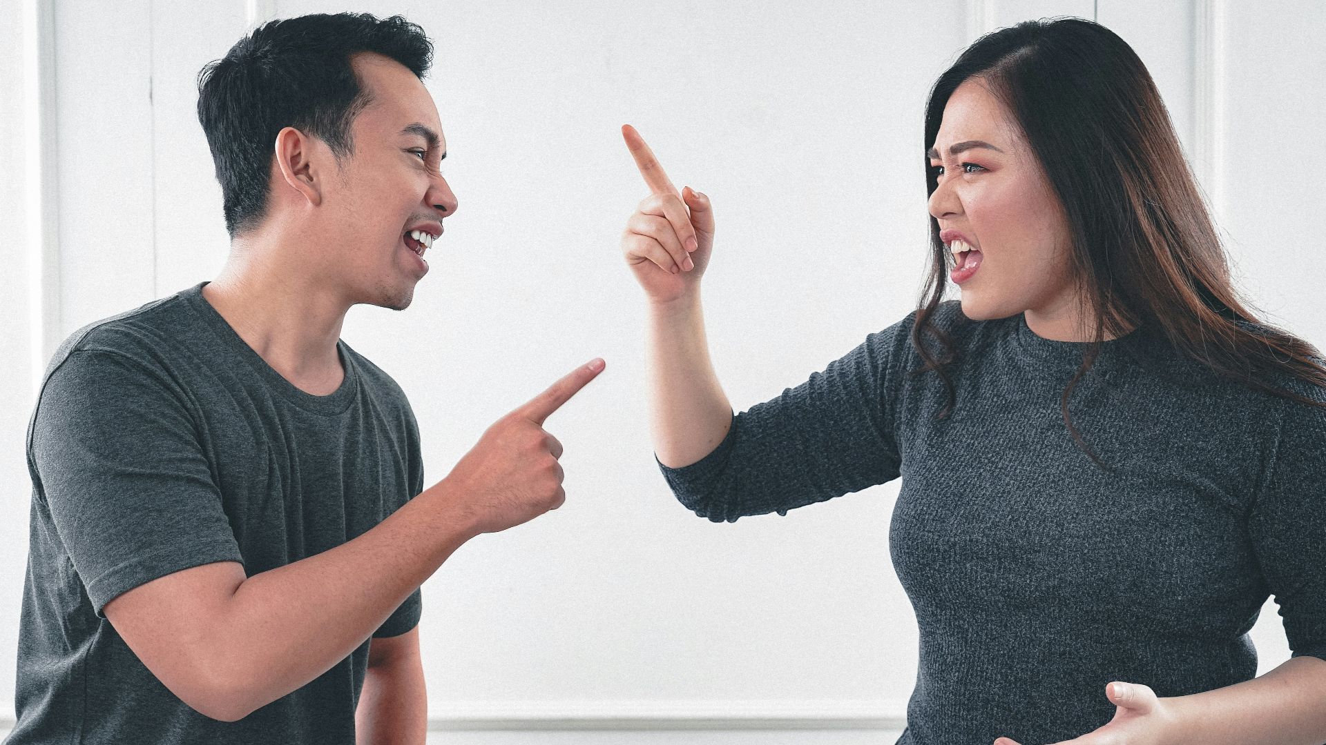 man in gray crew neck long sleeve shirt standing beside woman in black crew neck shirt