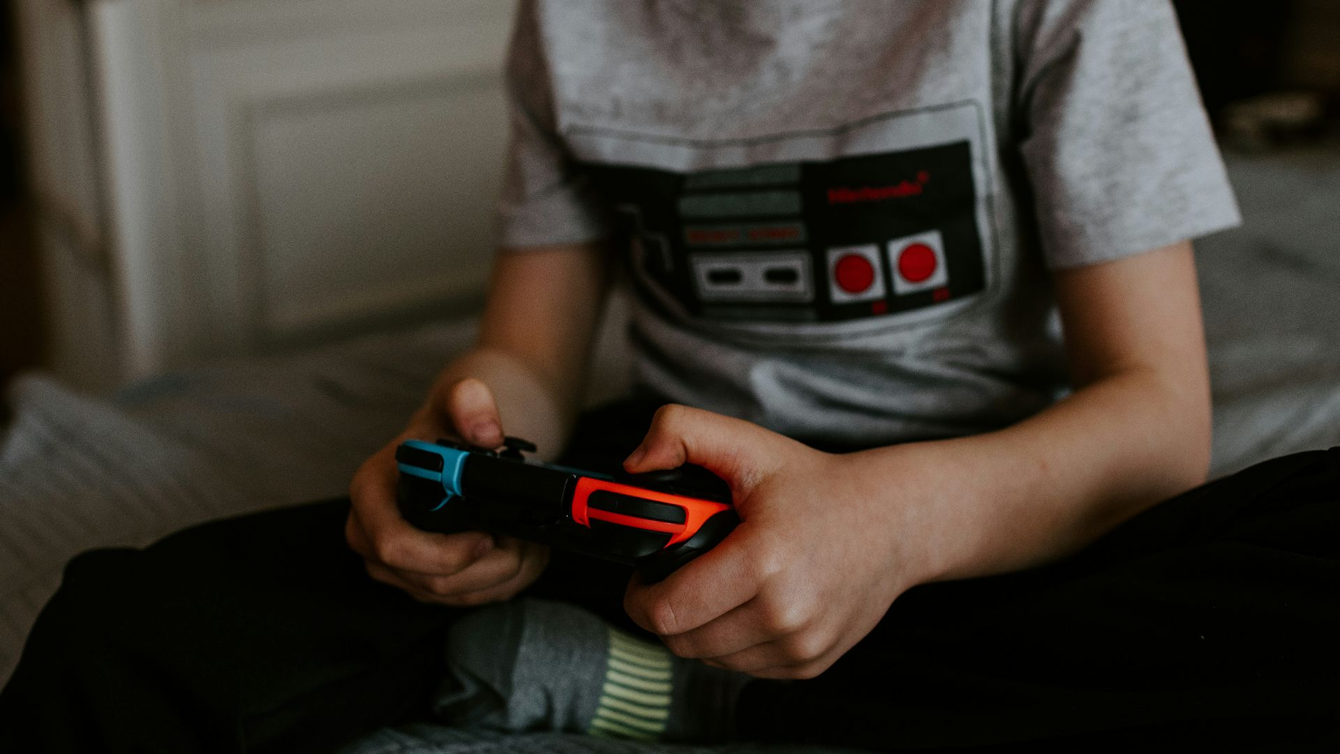 kid sitting on gray bed while playing