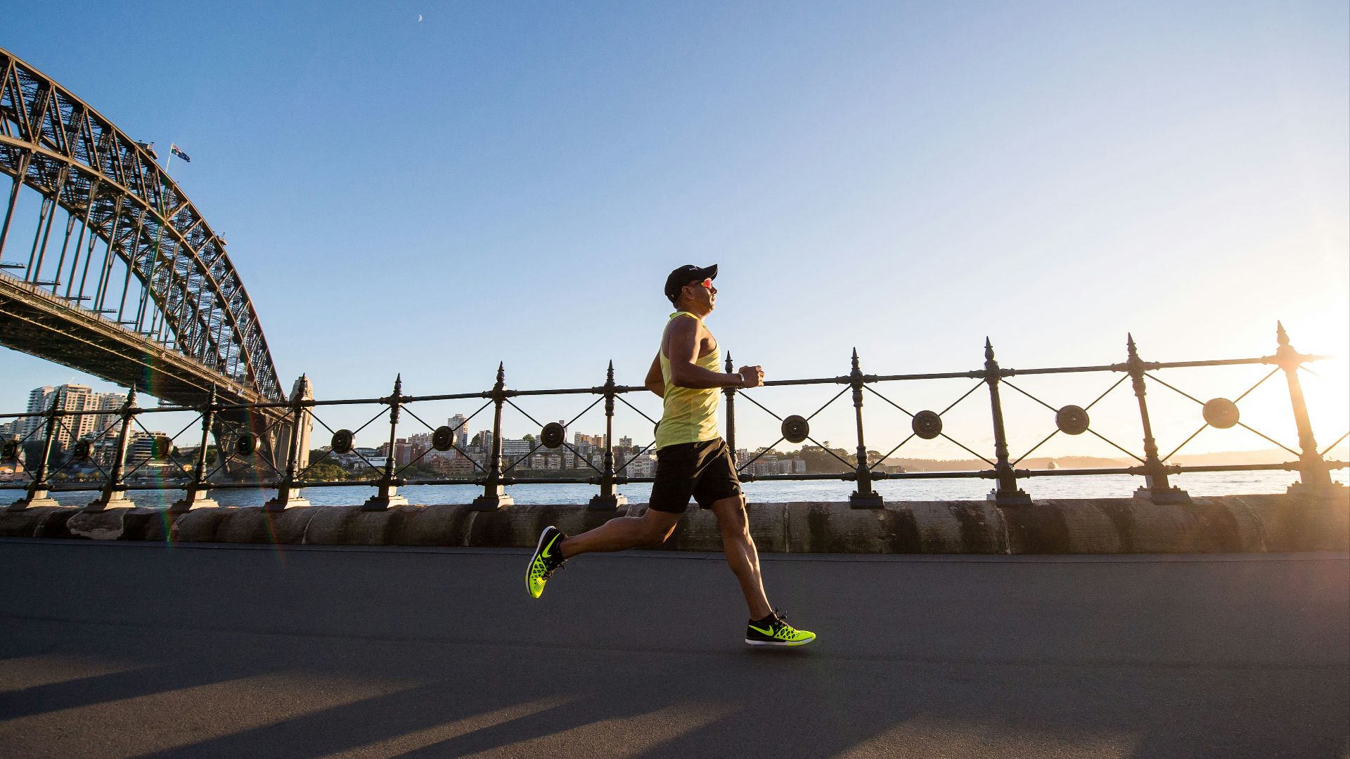 man in yellow tank top running near shore