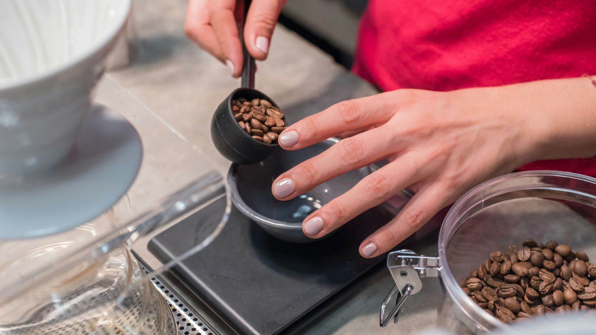 person scooping and measuring coffee beans
