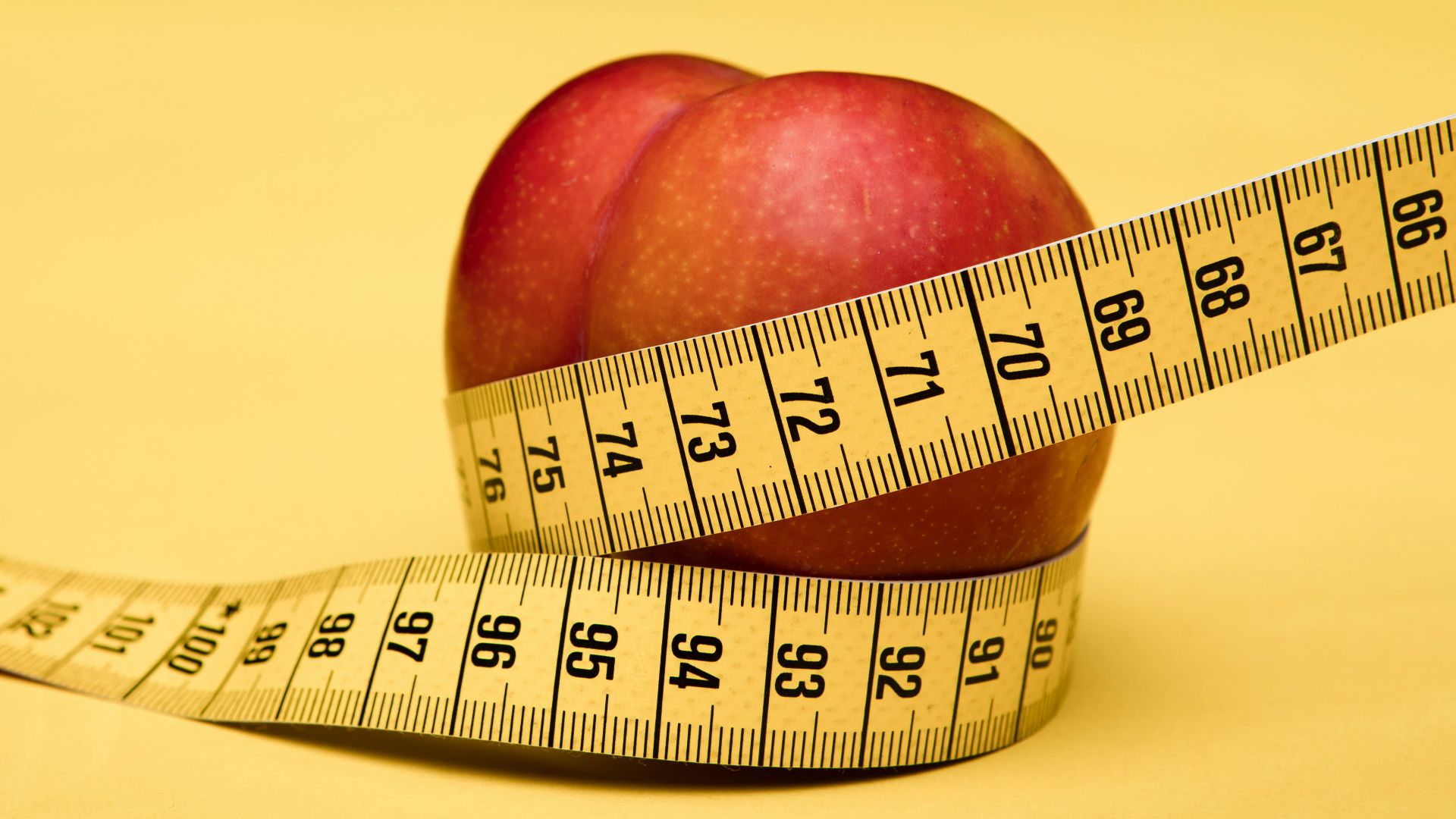 red apple fruit with tape measure