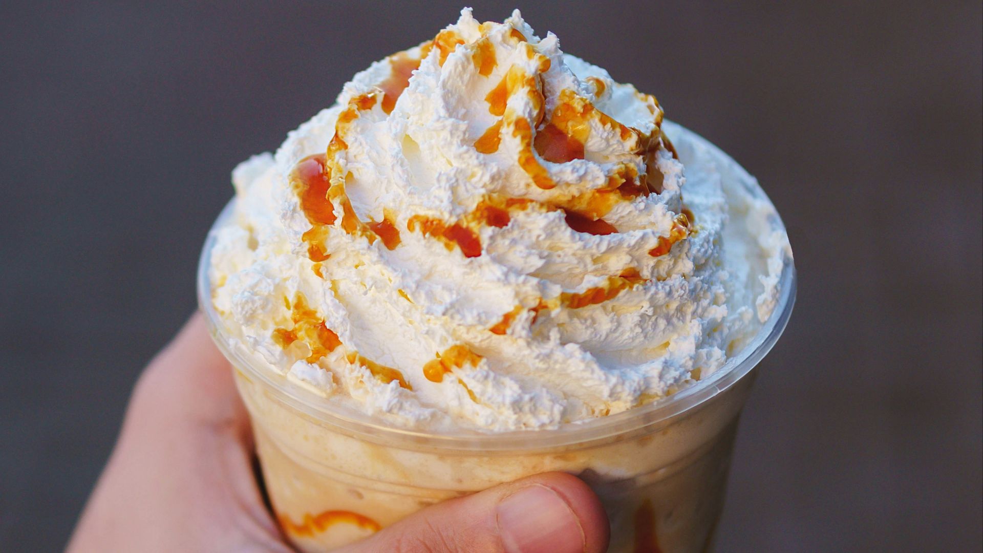 a hand holding a cup of ice cream