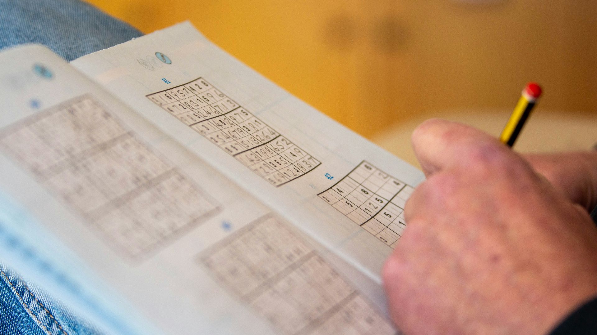 a person is holding a piece of paper with numbers on it