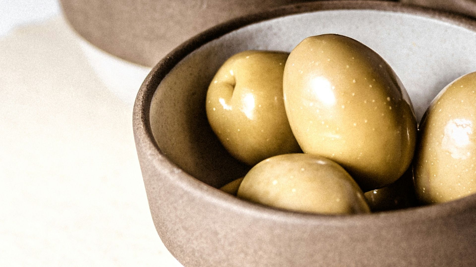 green round fruits on black ceramic bowl