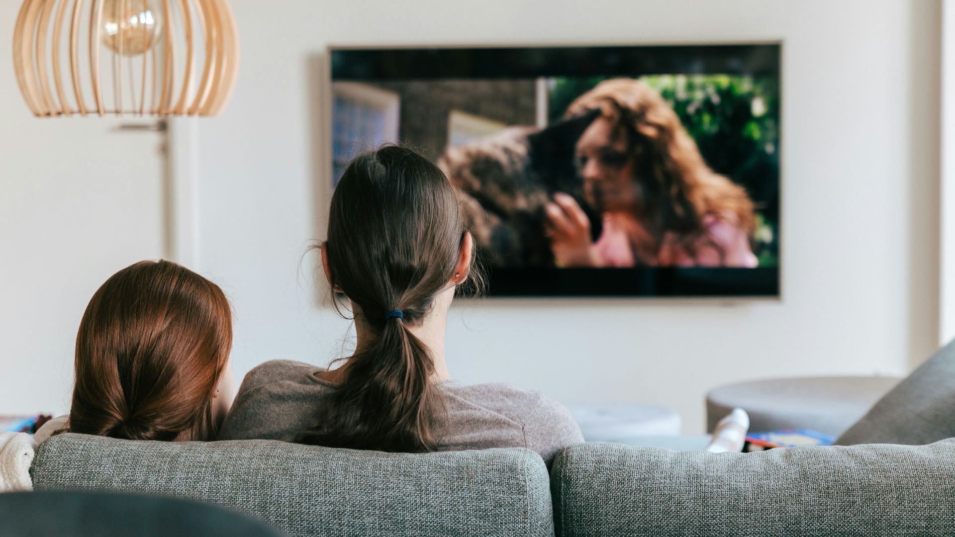 a couple of women sitting on top of a couch