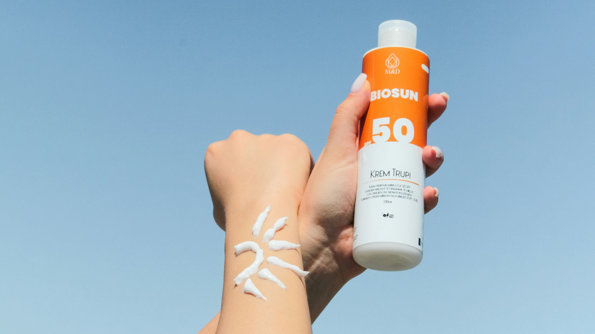 a person holding a bottle of sunscreen in their hand