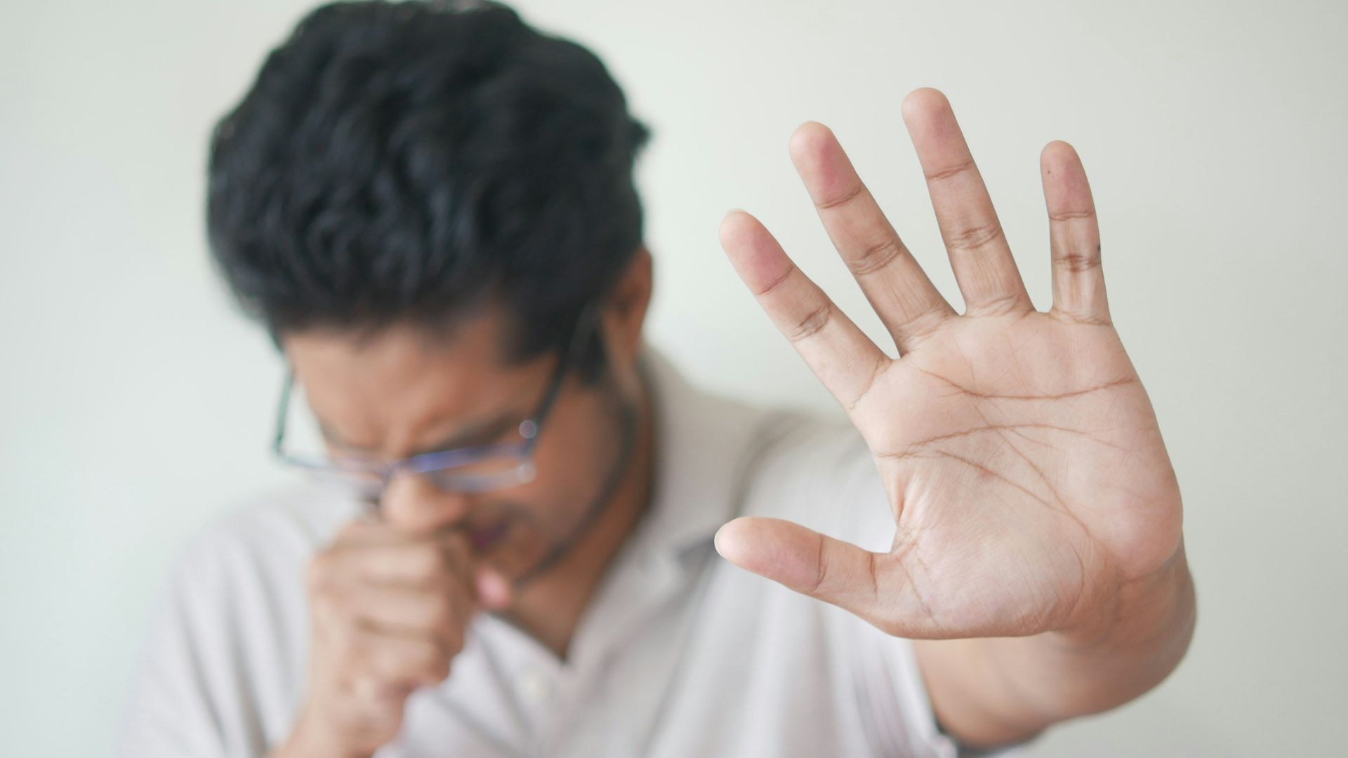 a man holding his hand up in front of his face