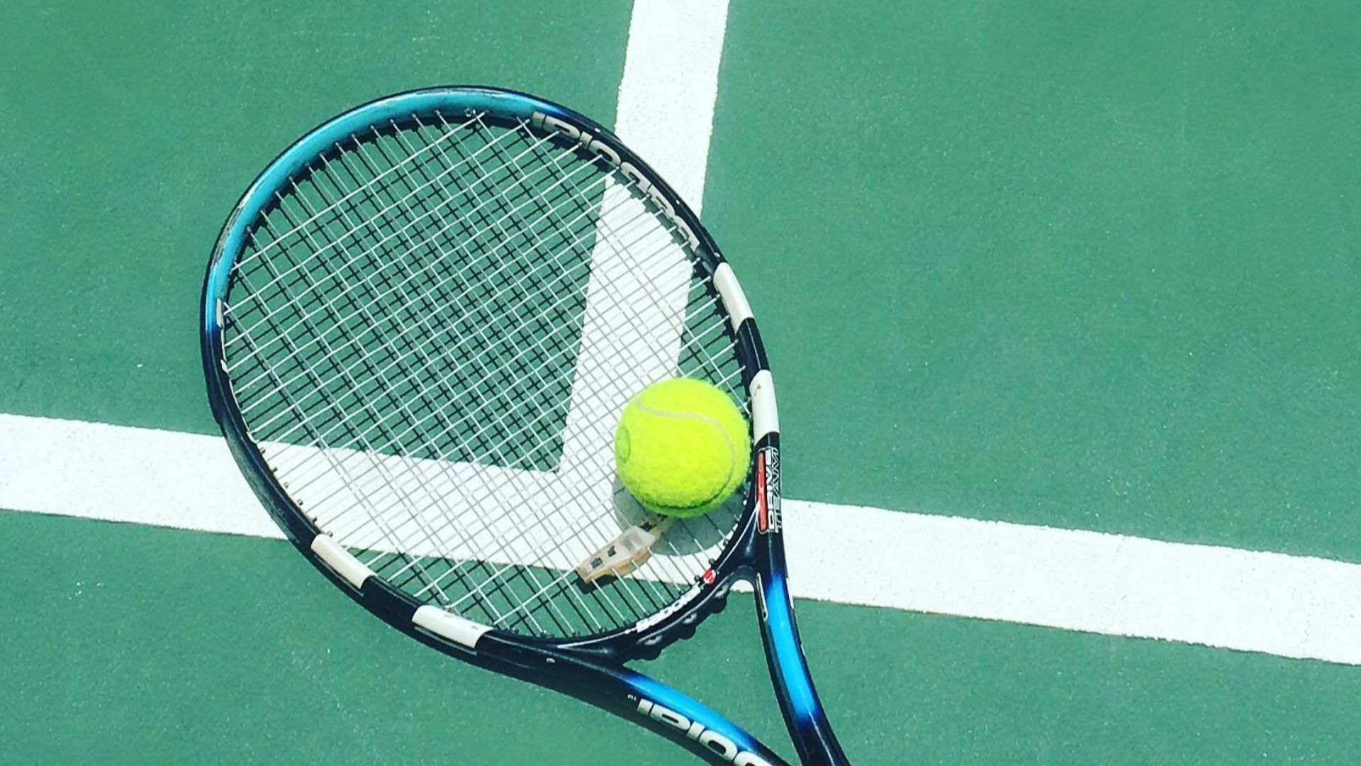 tennis racket and ball on field