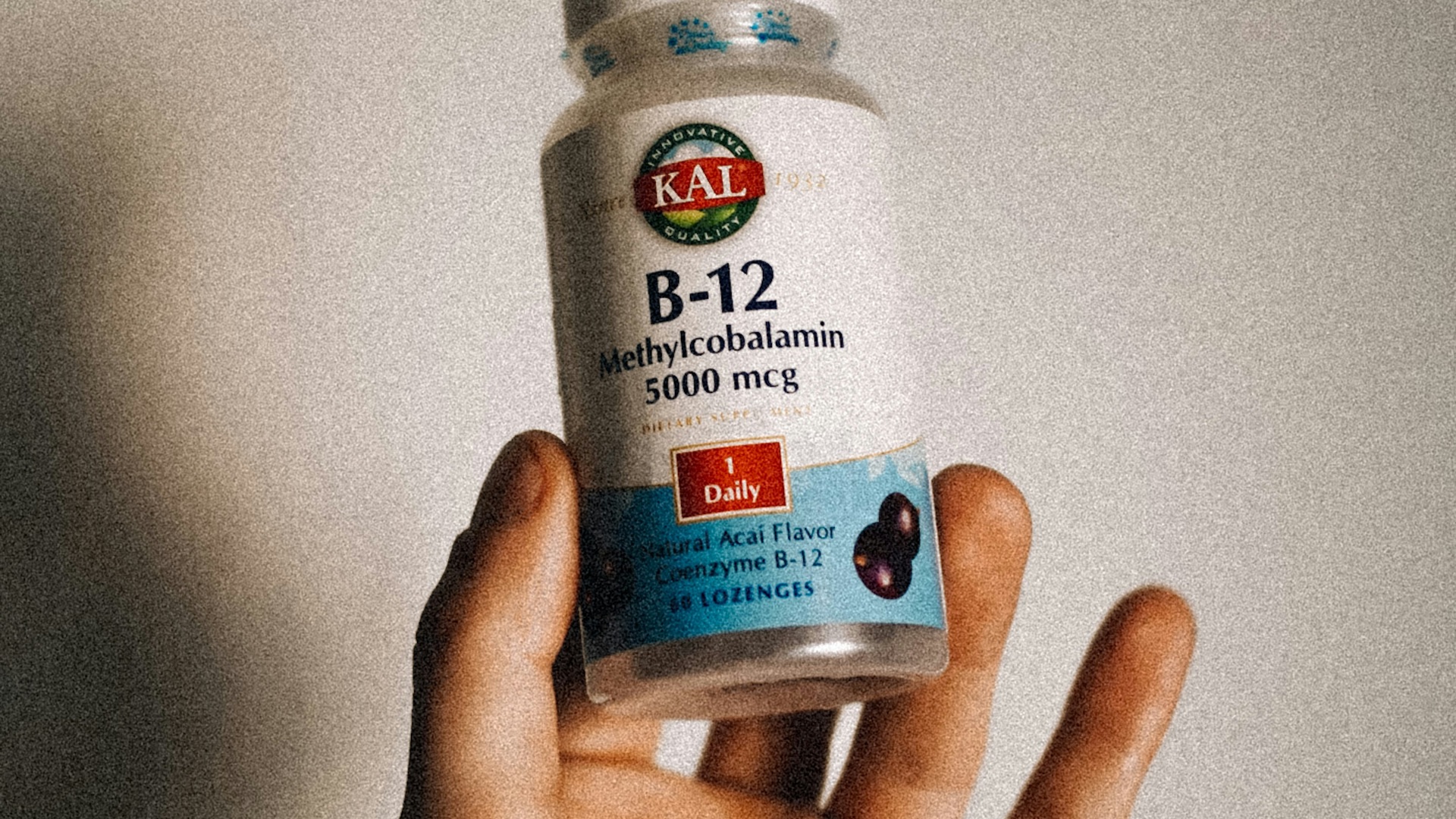 a person holding a bottle of vitamins in their hand