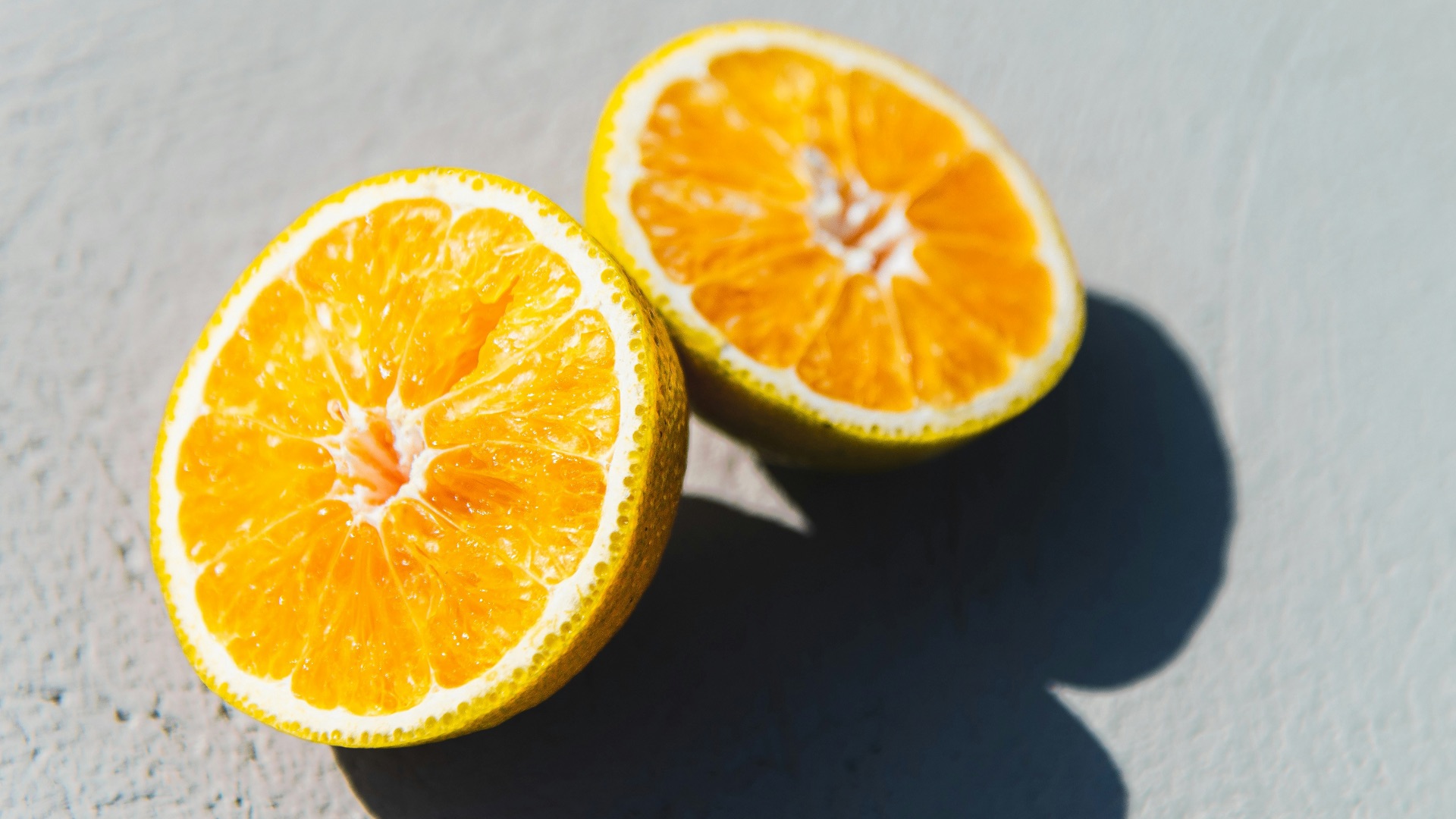 two oranges cut in half sitting on a table