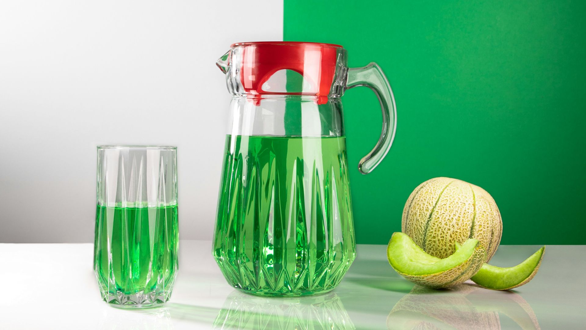 Green drink in pitcher and glass with melon