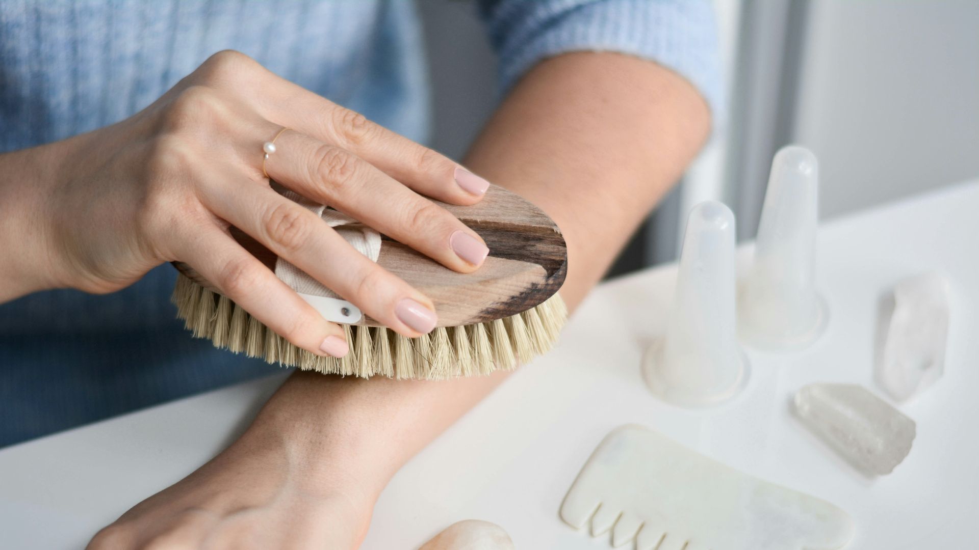 a woman brushes her nails with a brush