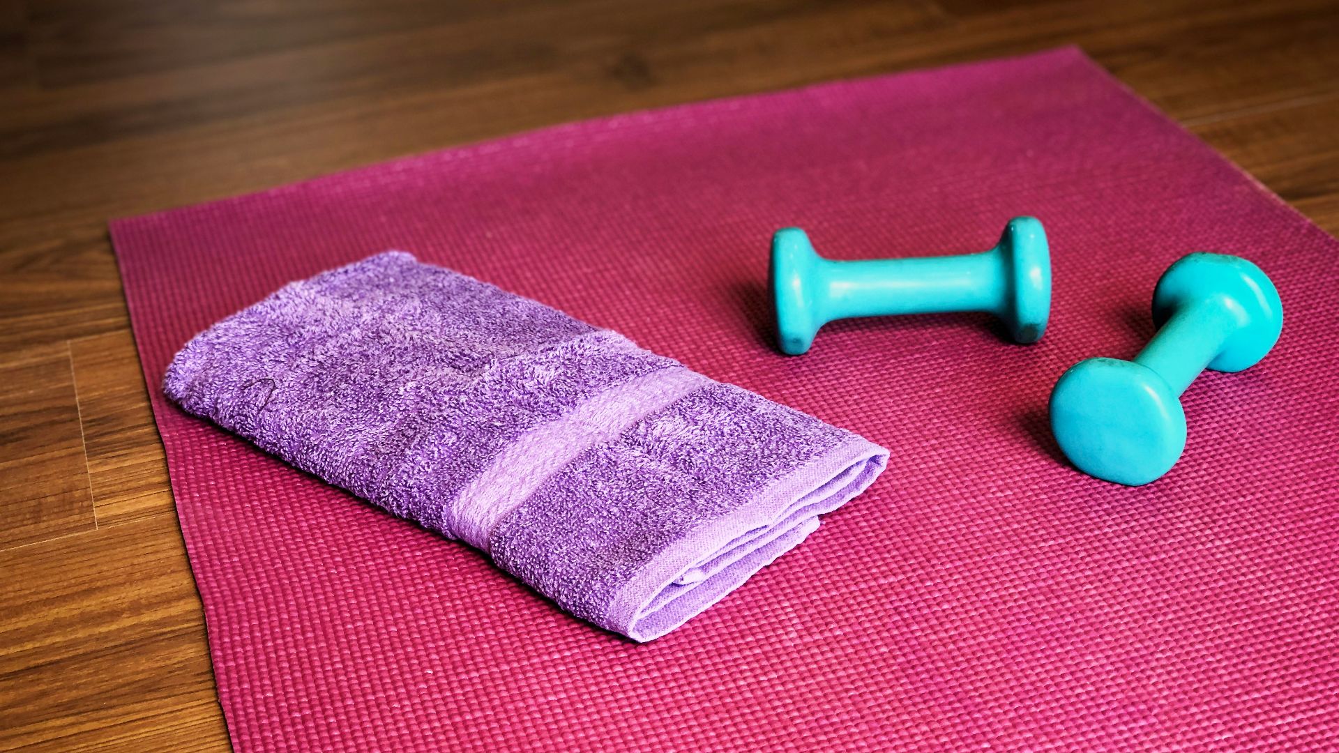 Yoga mat, weights, and a towel ready for a workout.