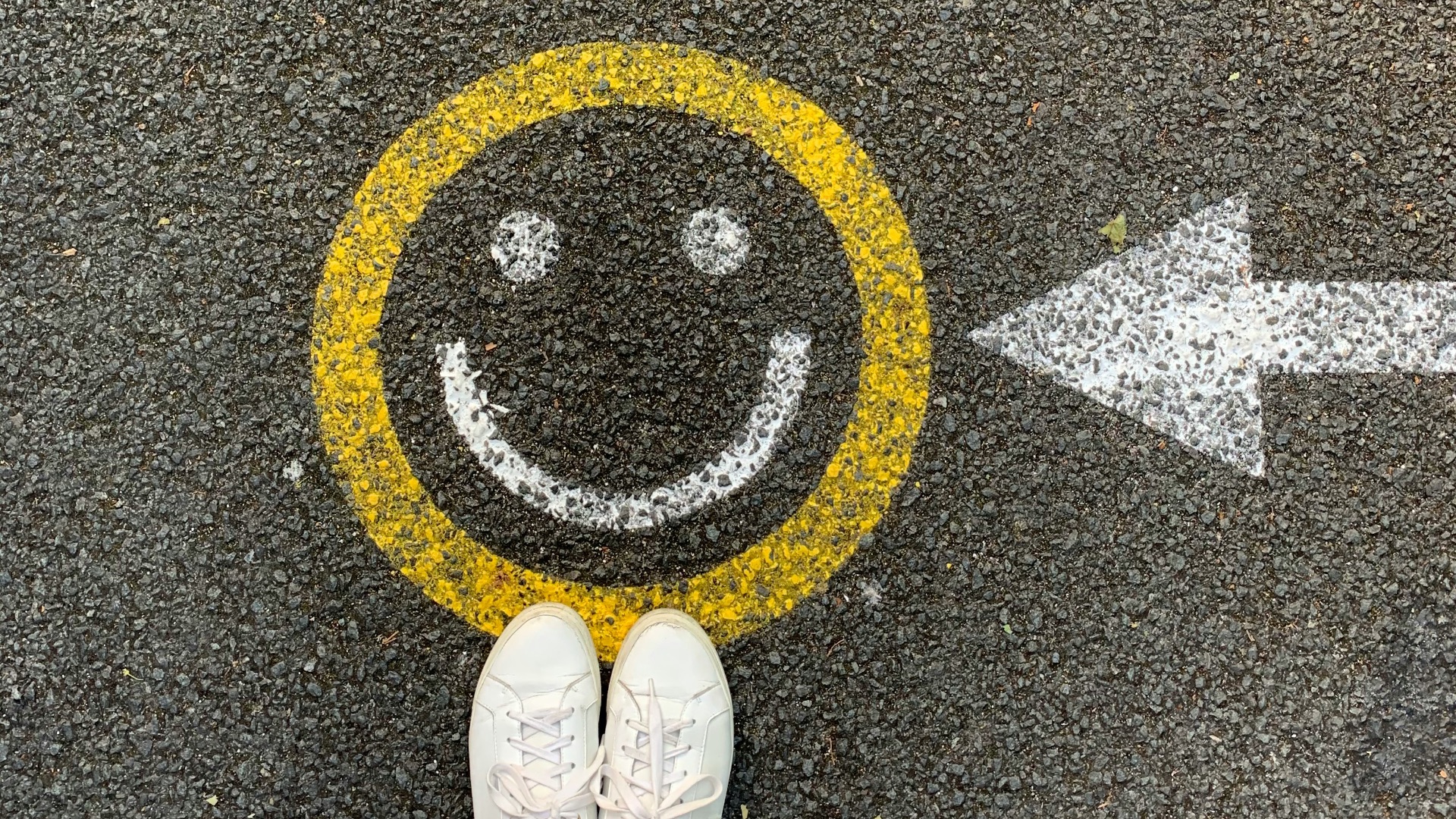 person in white shoes standing on gray concrete road