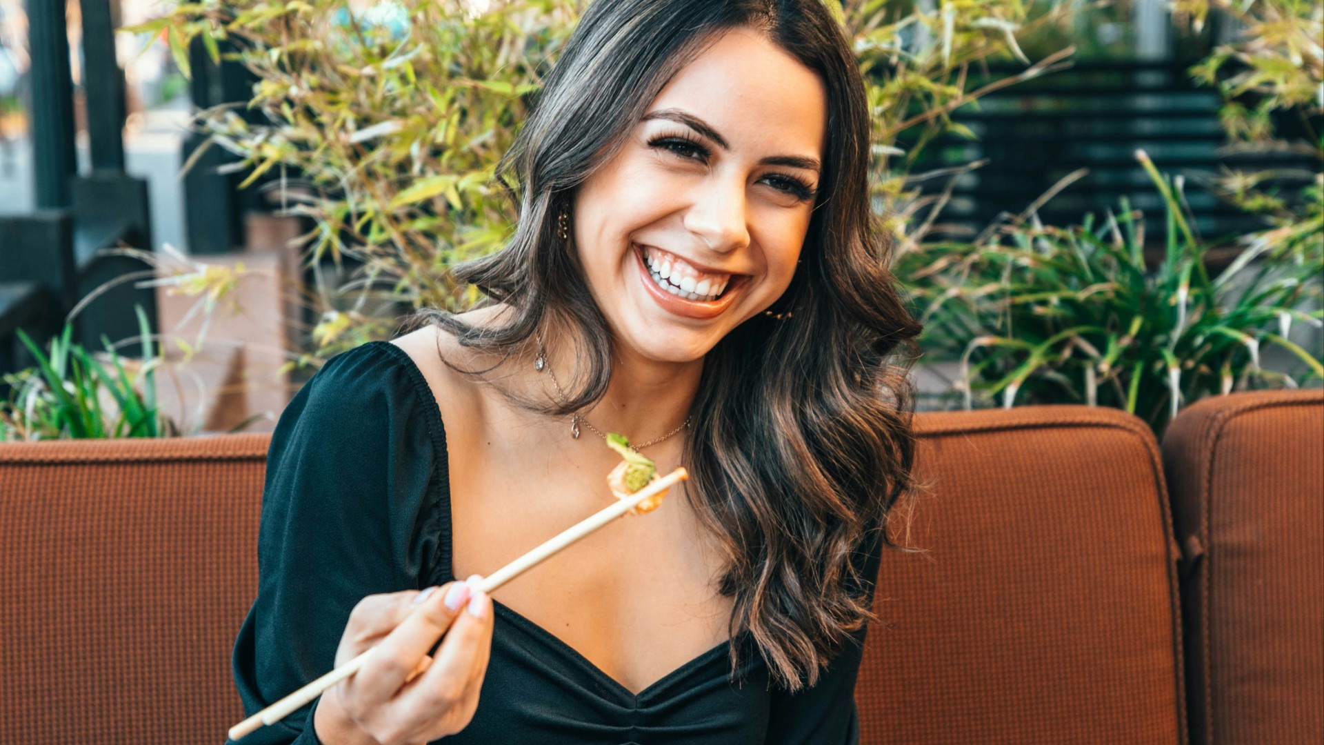 woman in blue long sleeve shirt holding chopsticks