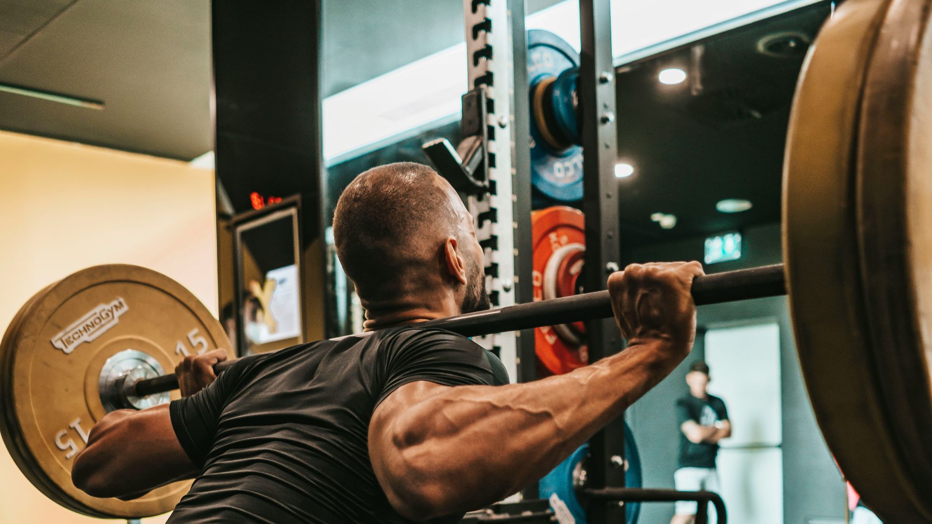 a man doing squats with a barbell in a gym