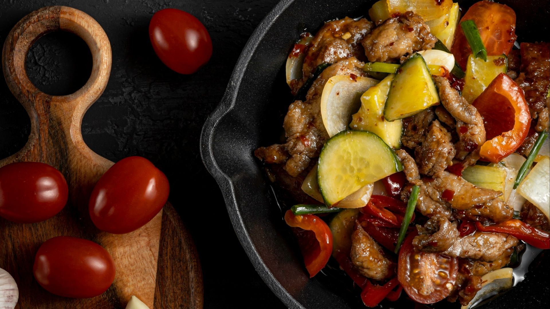 a pan filled with meat and vegetables next to garlic
