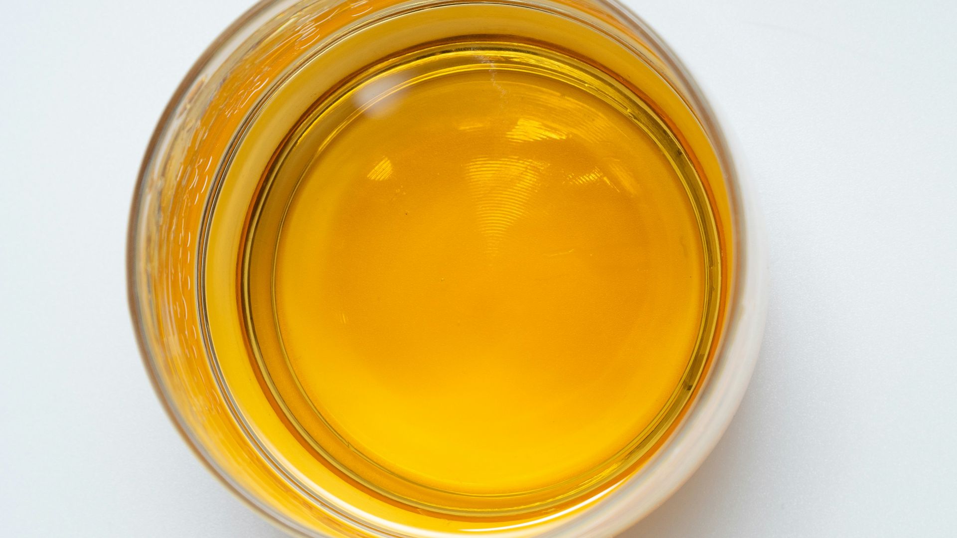 a glass filled with liquid sitting on top of a white table