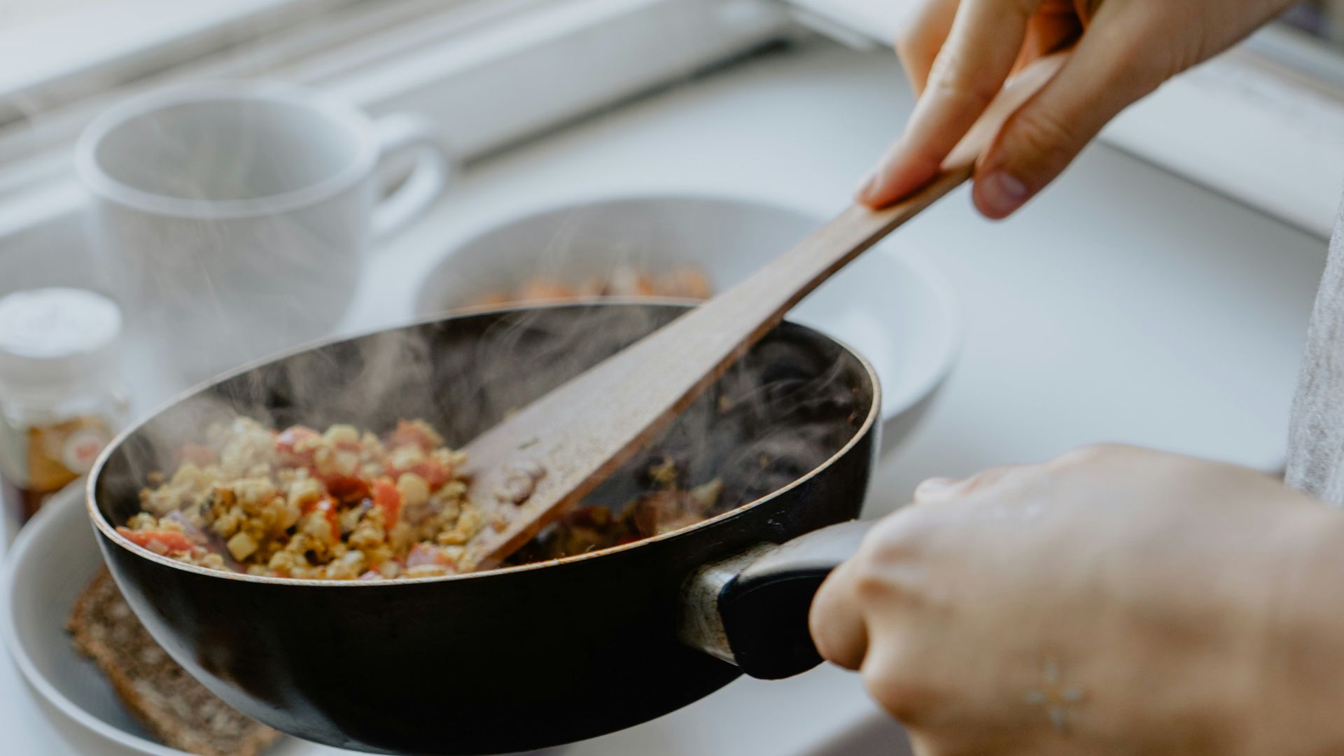 person holding black frying pan