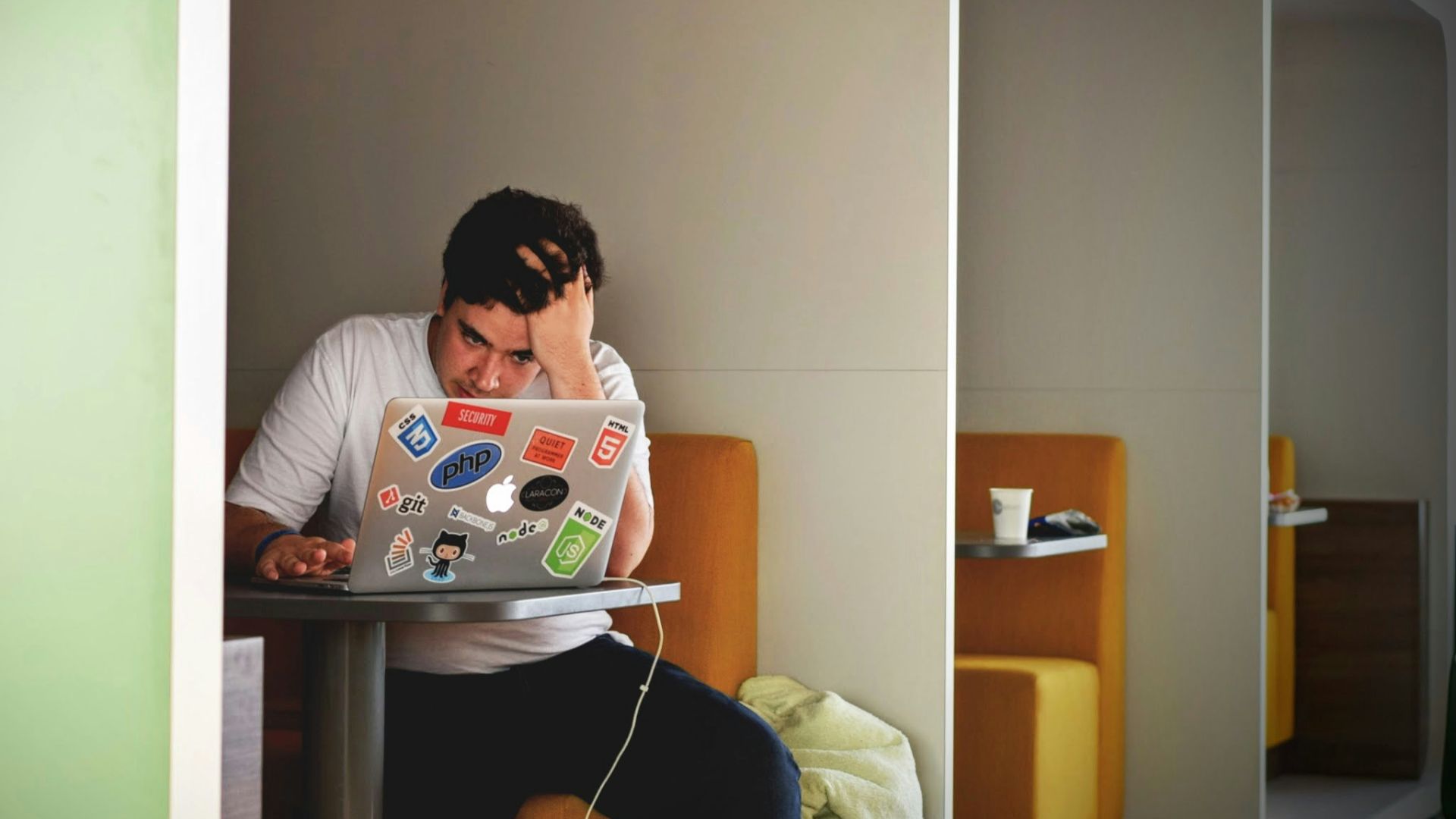 man wearing white top using MacBook