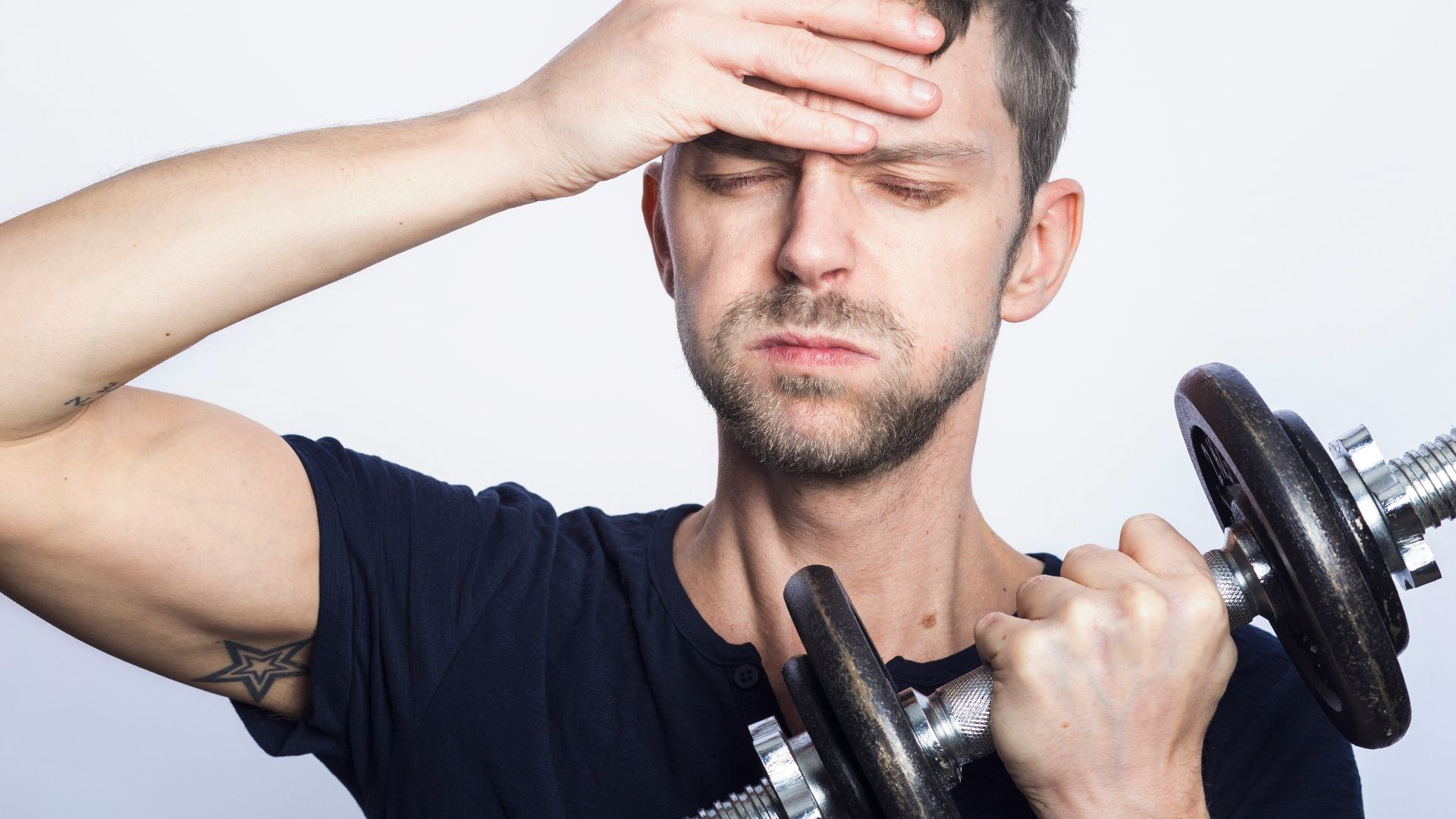 man in black crew neck t-shirt holding black dumbbell