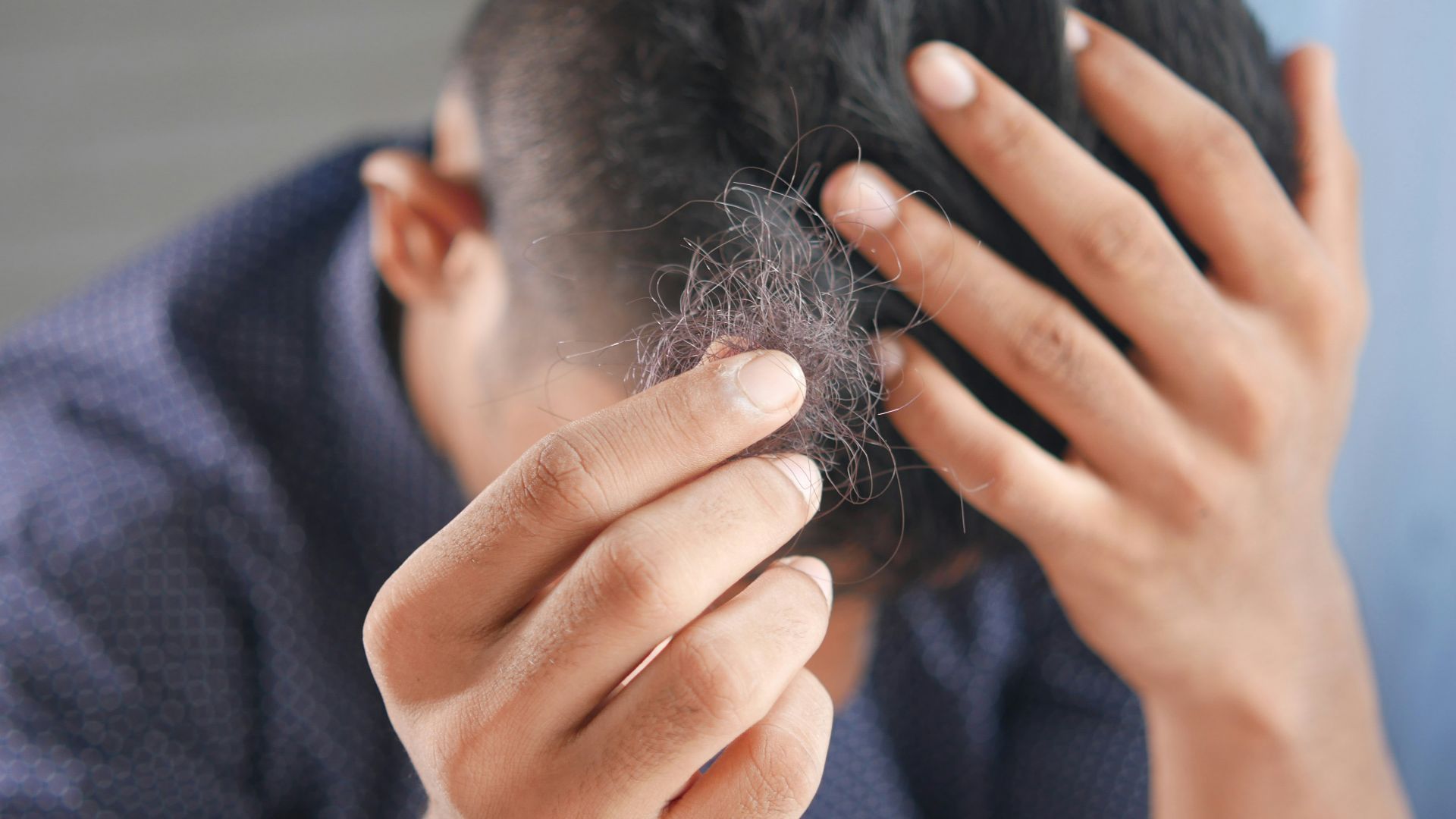 a man is combing his hair with his hands