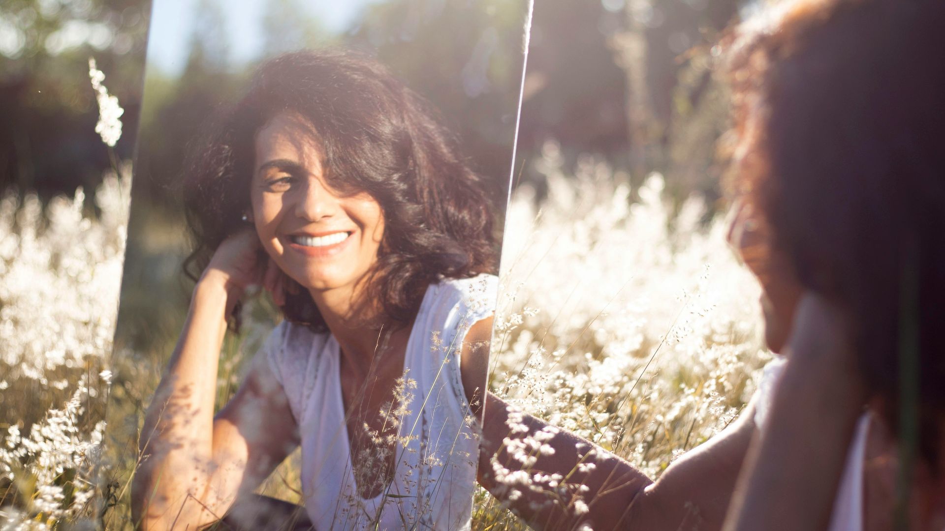 woman in blue and white floral shirt holding her face