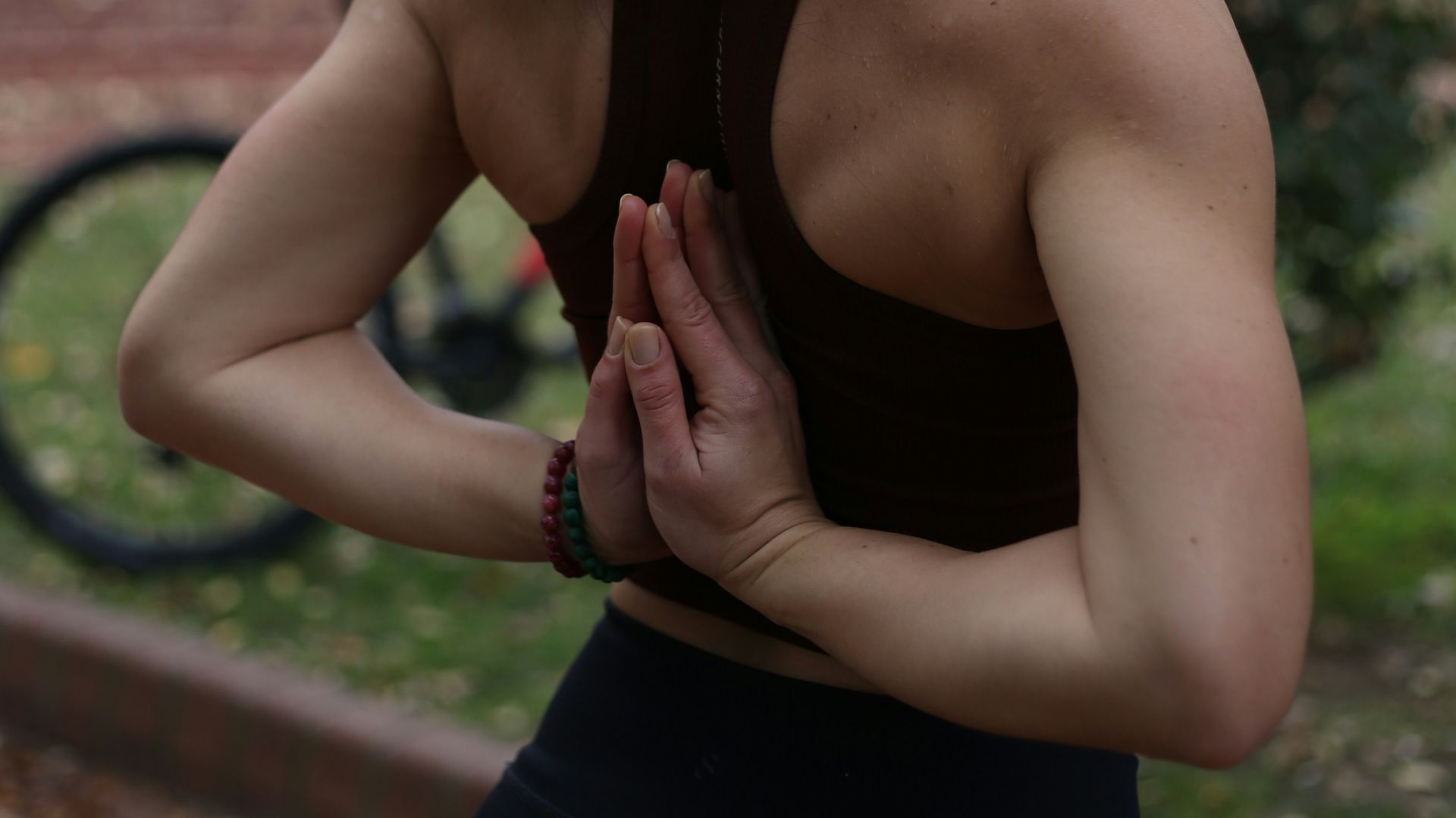 a woman standing in a park with her hands together