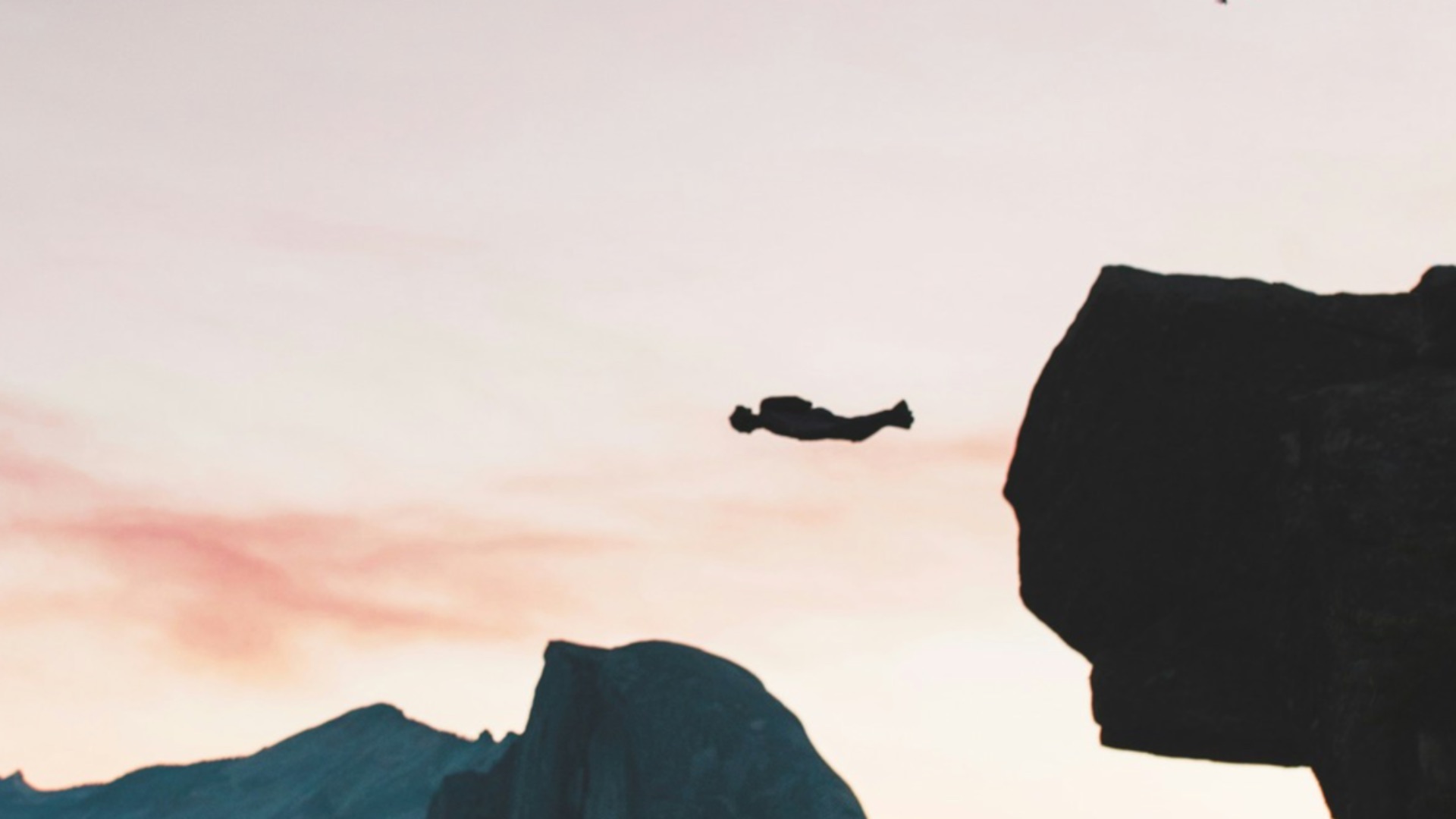 silhouette photography of man jumping with parachute