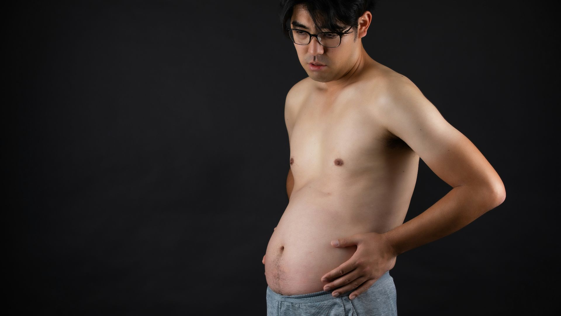 topless man in blue denim jeans