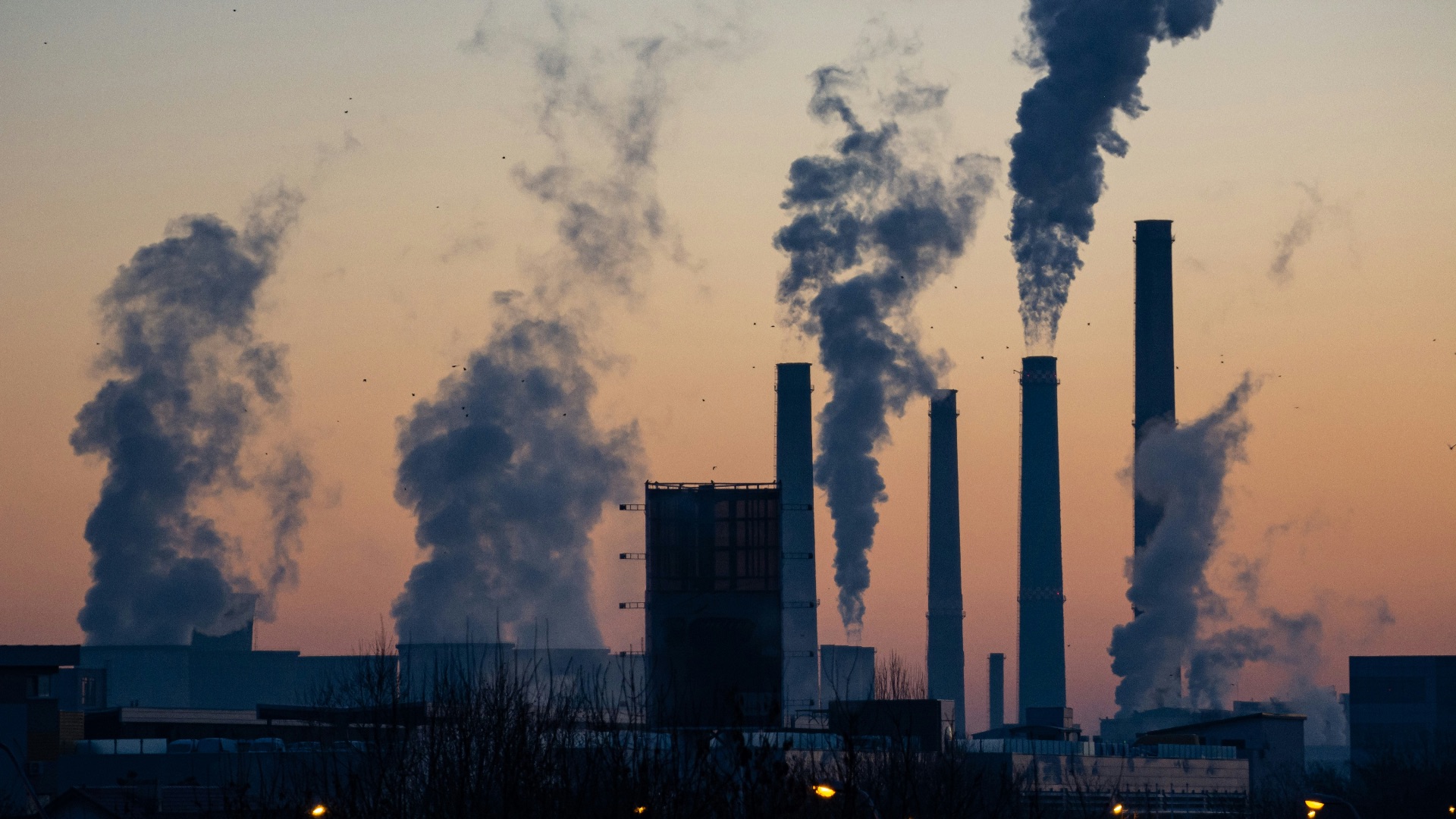 photography of smoke coming out from tower during daytime