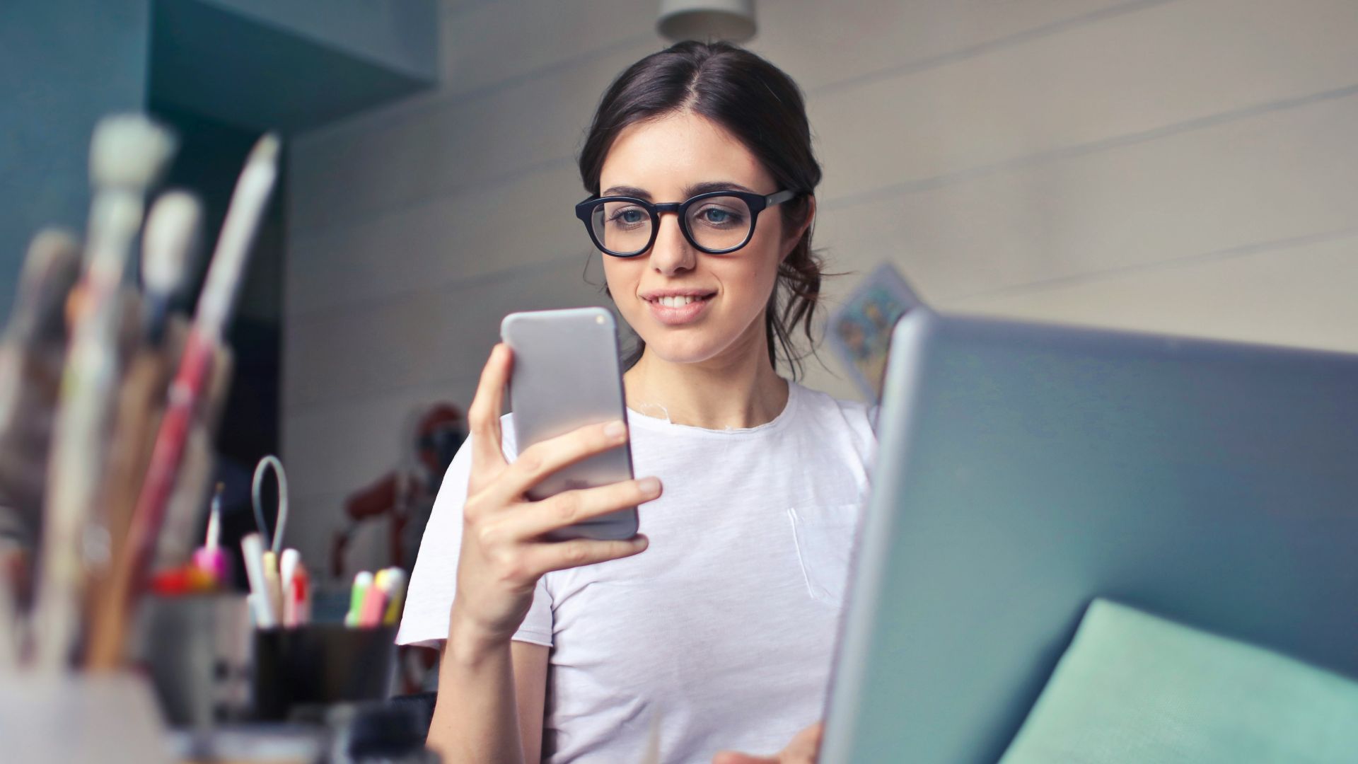 woman in white shirt using smartphone