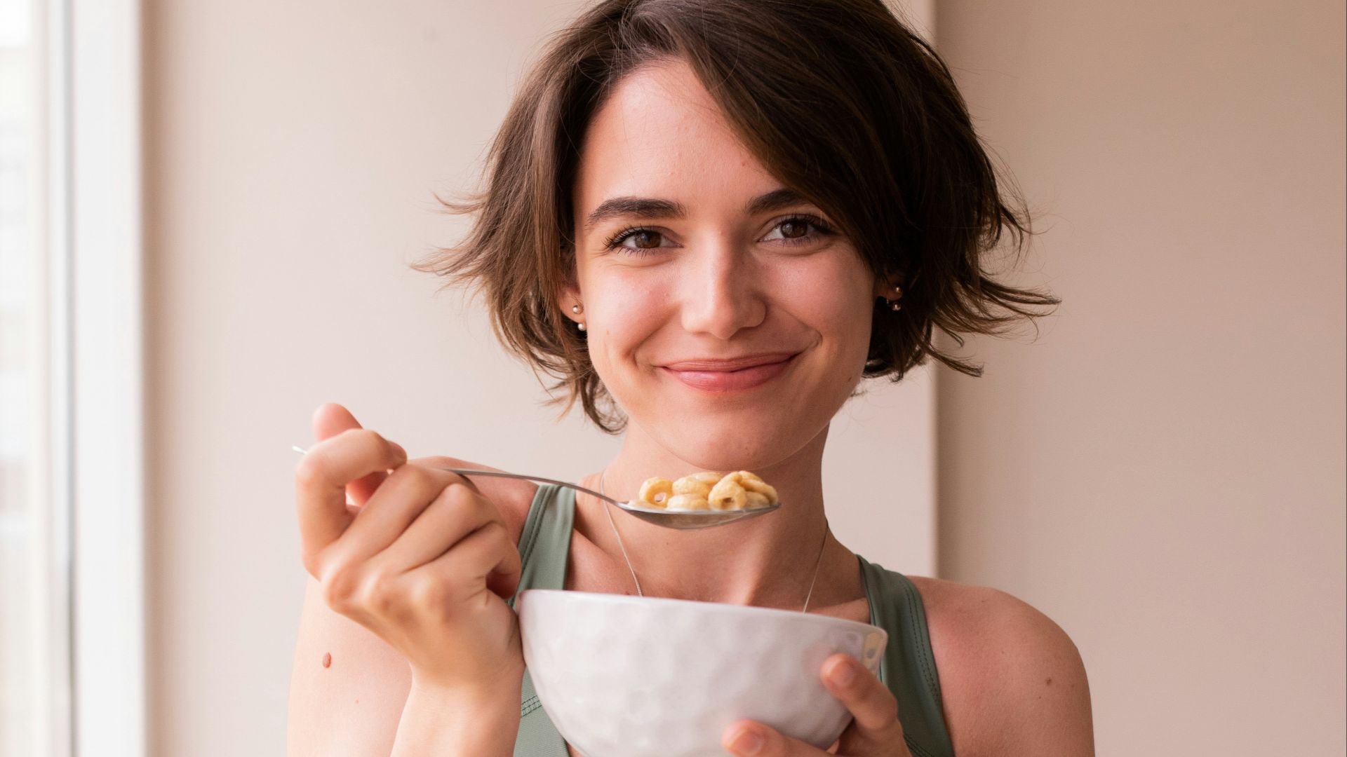 a woman in a sports bra top holding a bowl of food