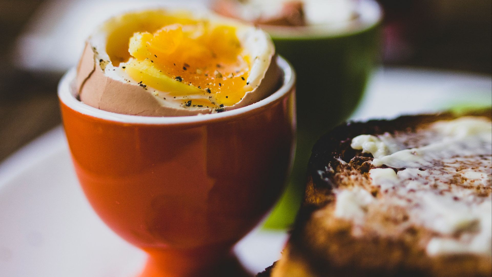 an egg is in a bowl on a plate next to toast