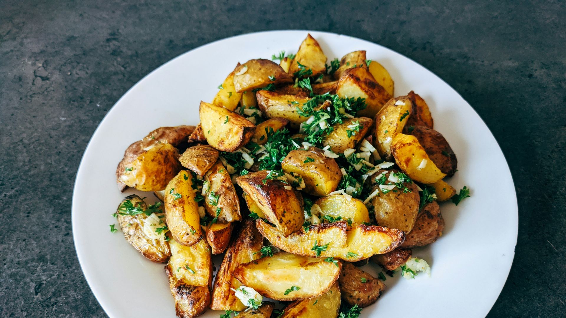 a white plate topped with potatoes and parsley