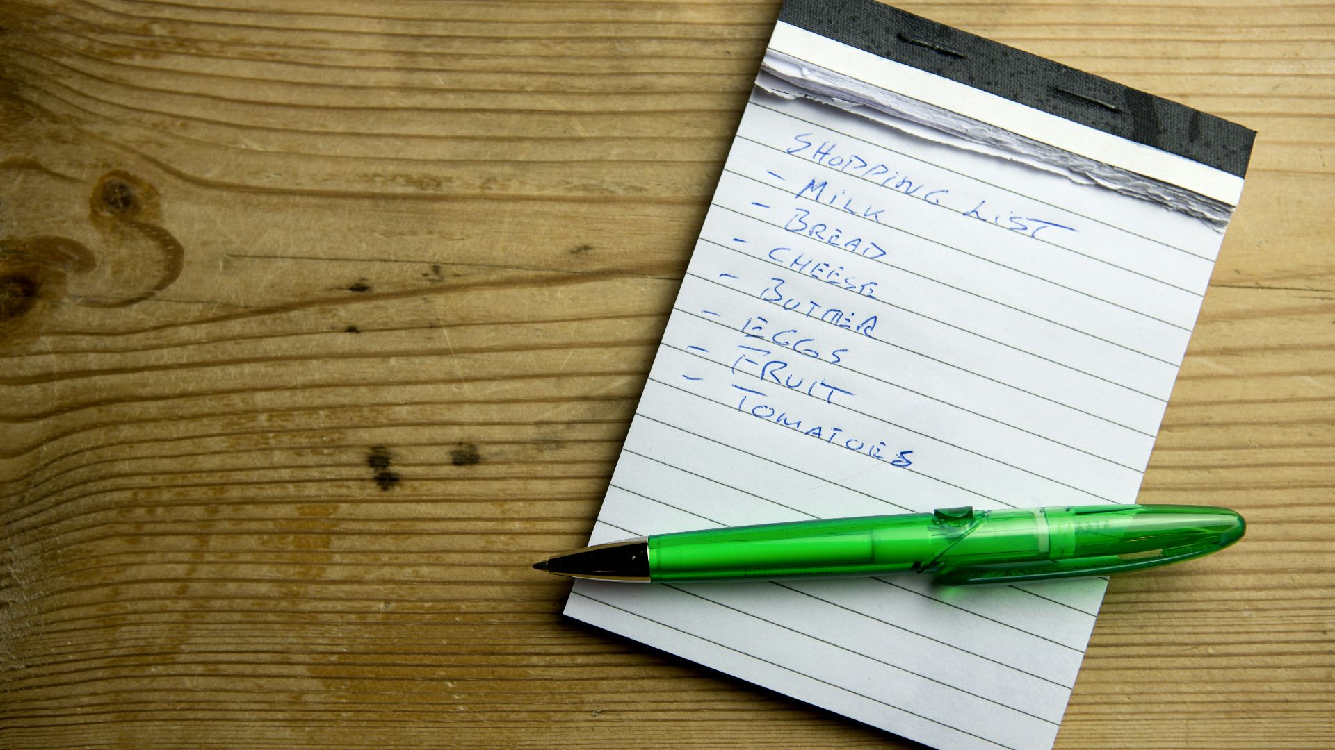 a notepad with a green pen on top of it