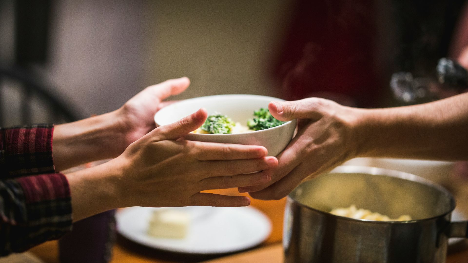 a couple of people holding a bowl of food
