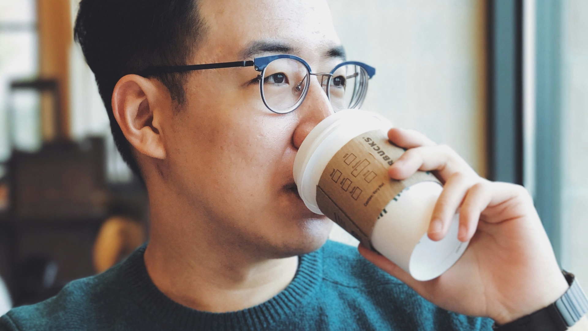 man holding Starbucks disposable cup
