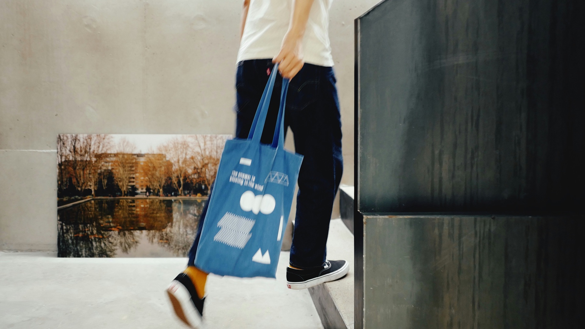 a man carrying a blue shopping bag up a flight of stairs