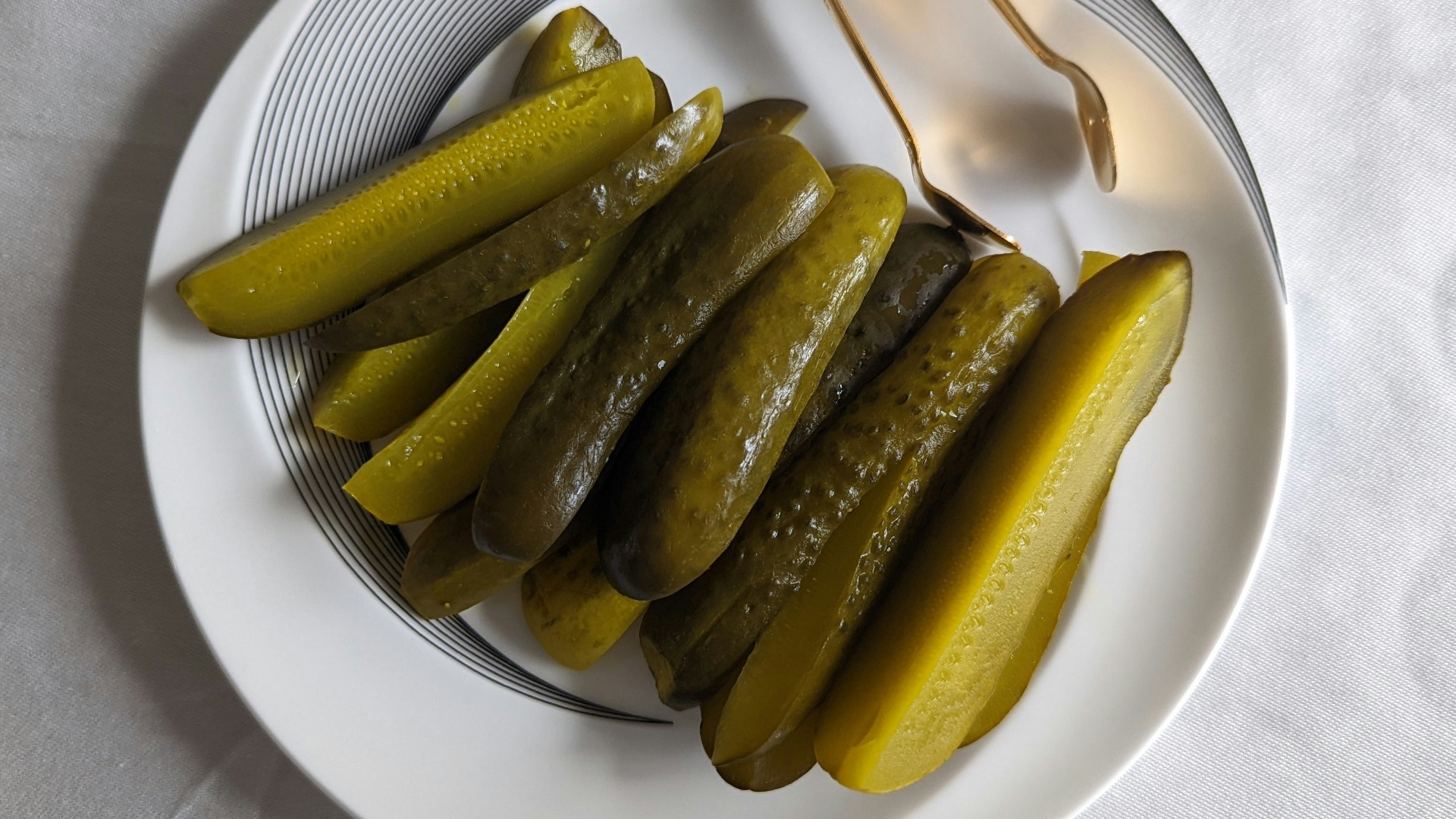a white plate topped with pickles next to a fork