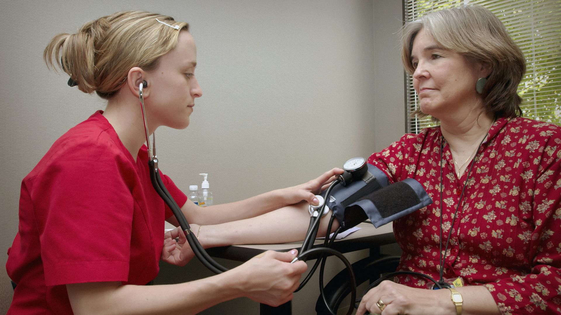 a woman with a stethoscope listening to a patient