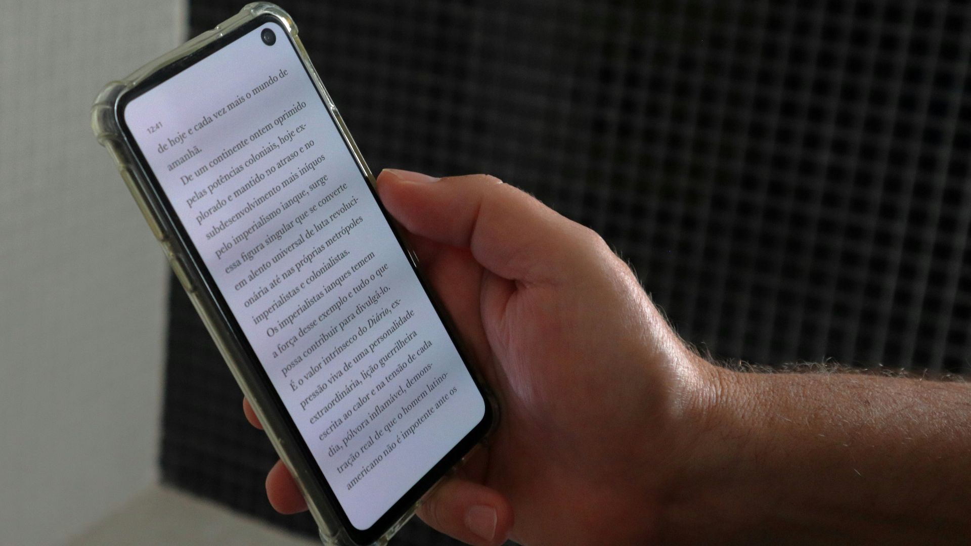 a person holding a smart phone with a book on the screen