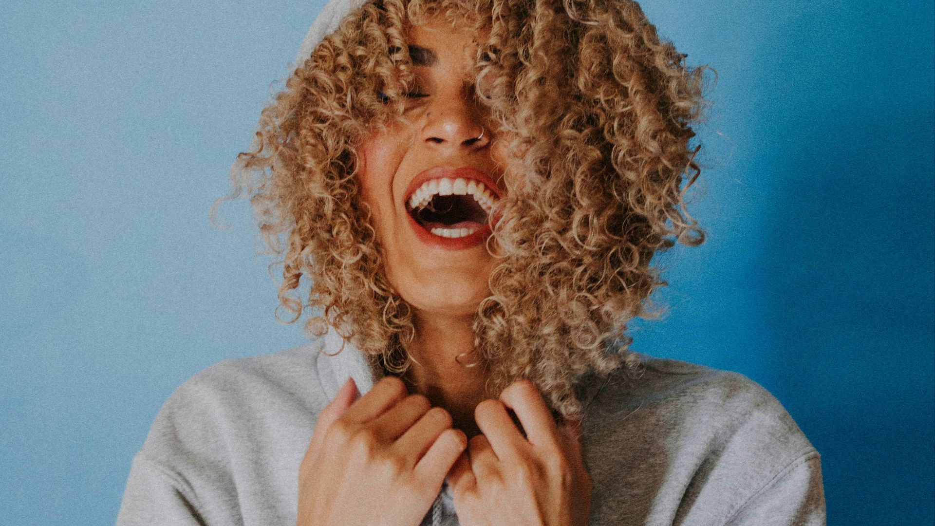 smiling woman wearing gray hoodie